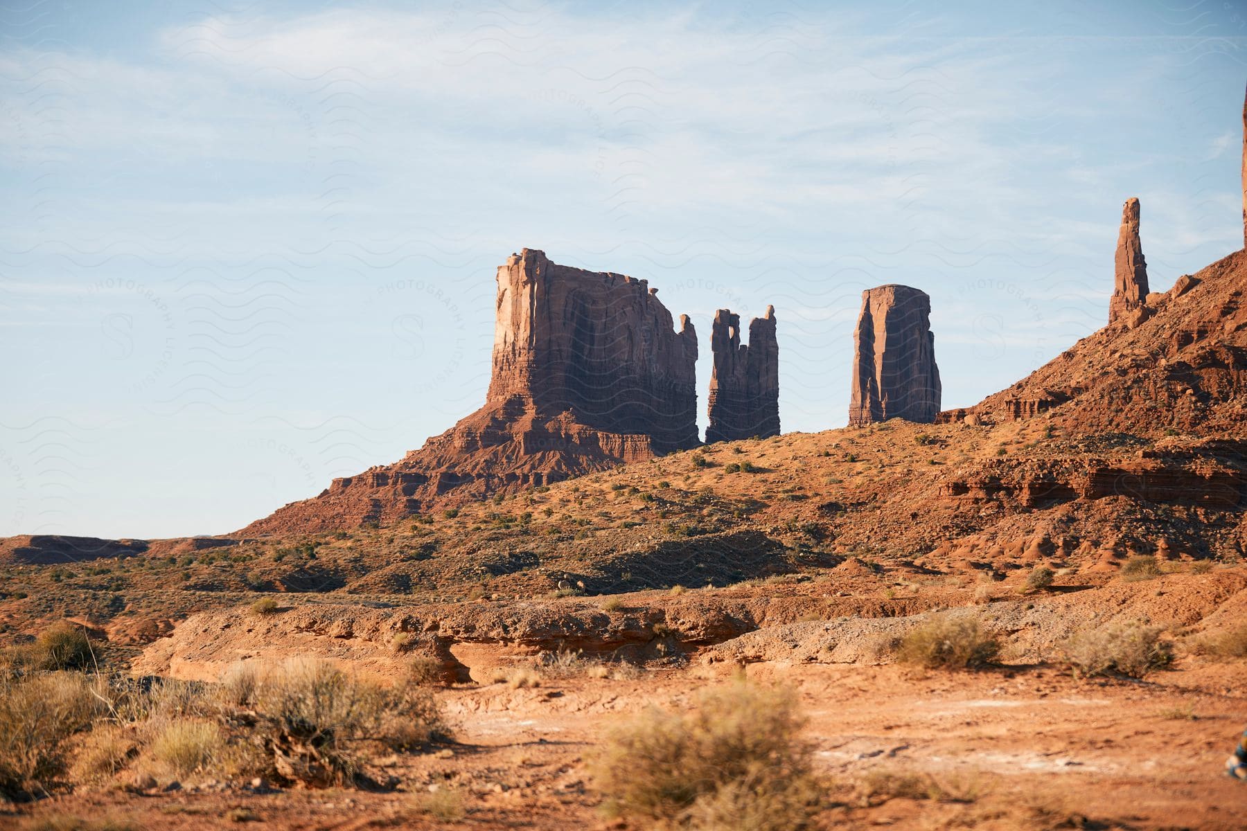 A desert with tall rock landmarks on a hill.