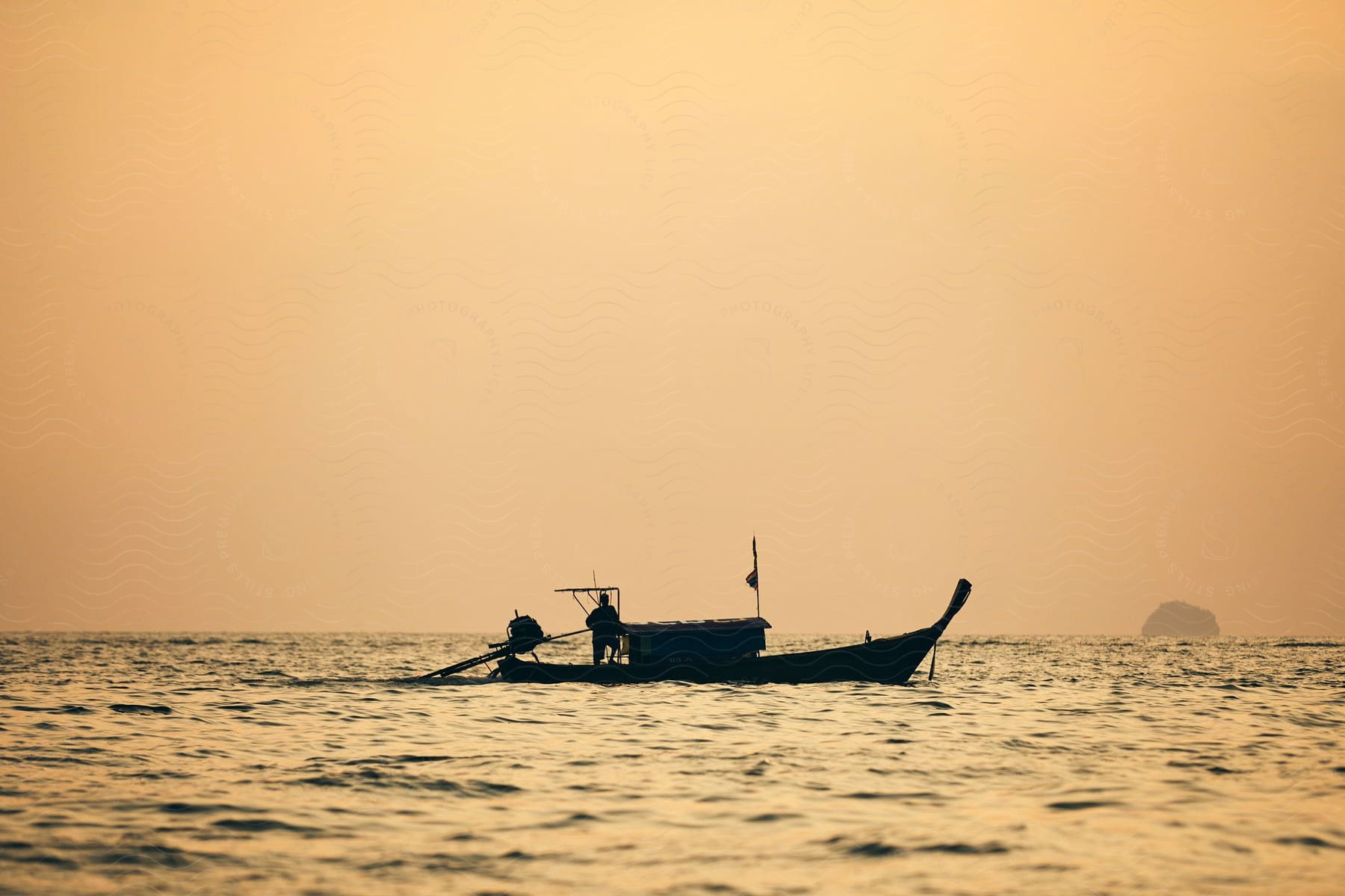 A person is driving a boat on the ocean during sunset.