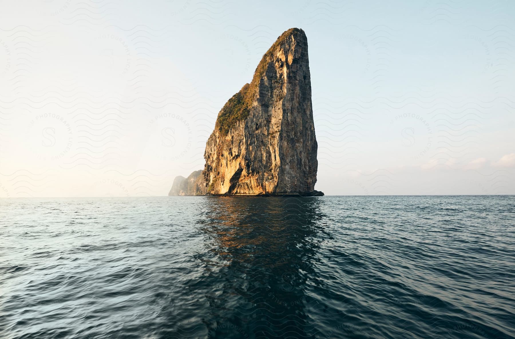 Rocky island in the middle of the ocean during the day.