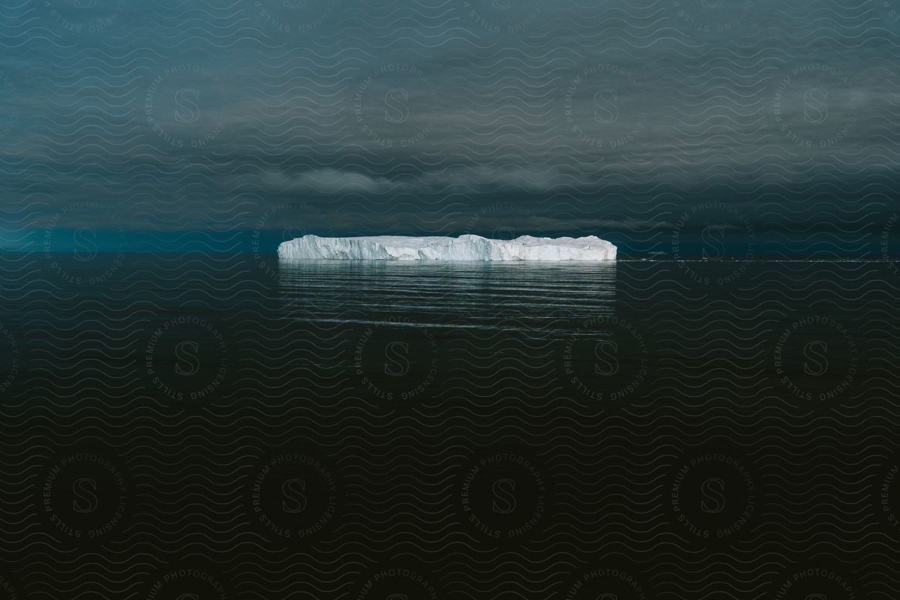 A block of ice floating in a dark sea.