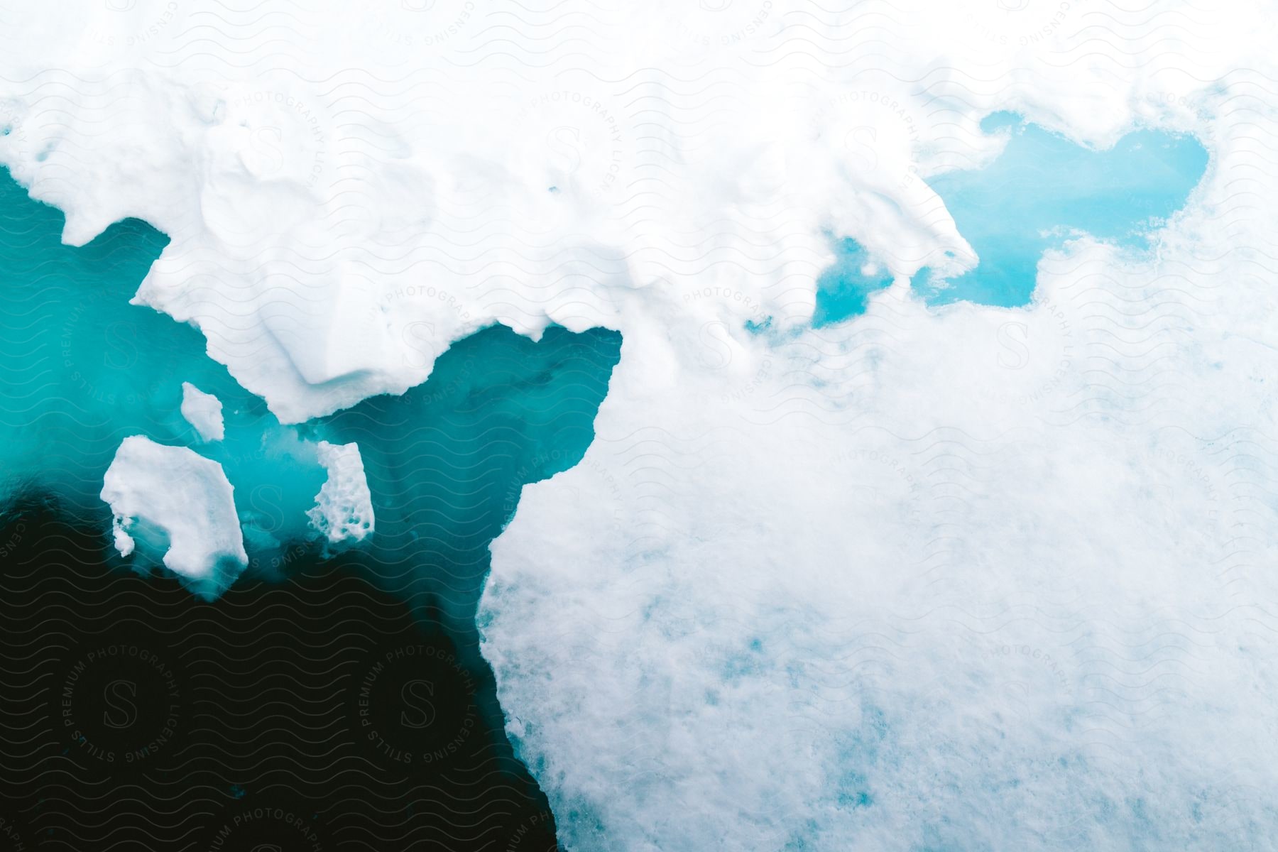 Aerial of polar ice caps melting in the ocean in the middle of the day.