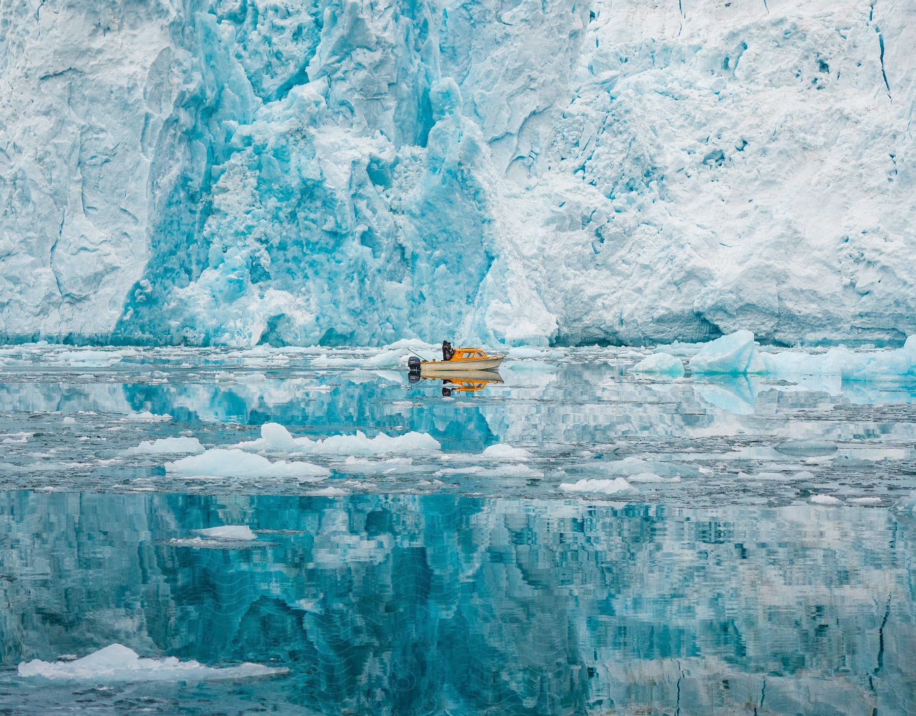 Small boat floating near Greenland ice sheet