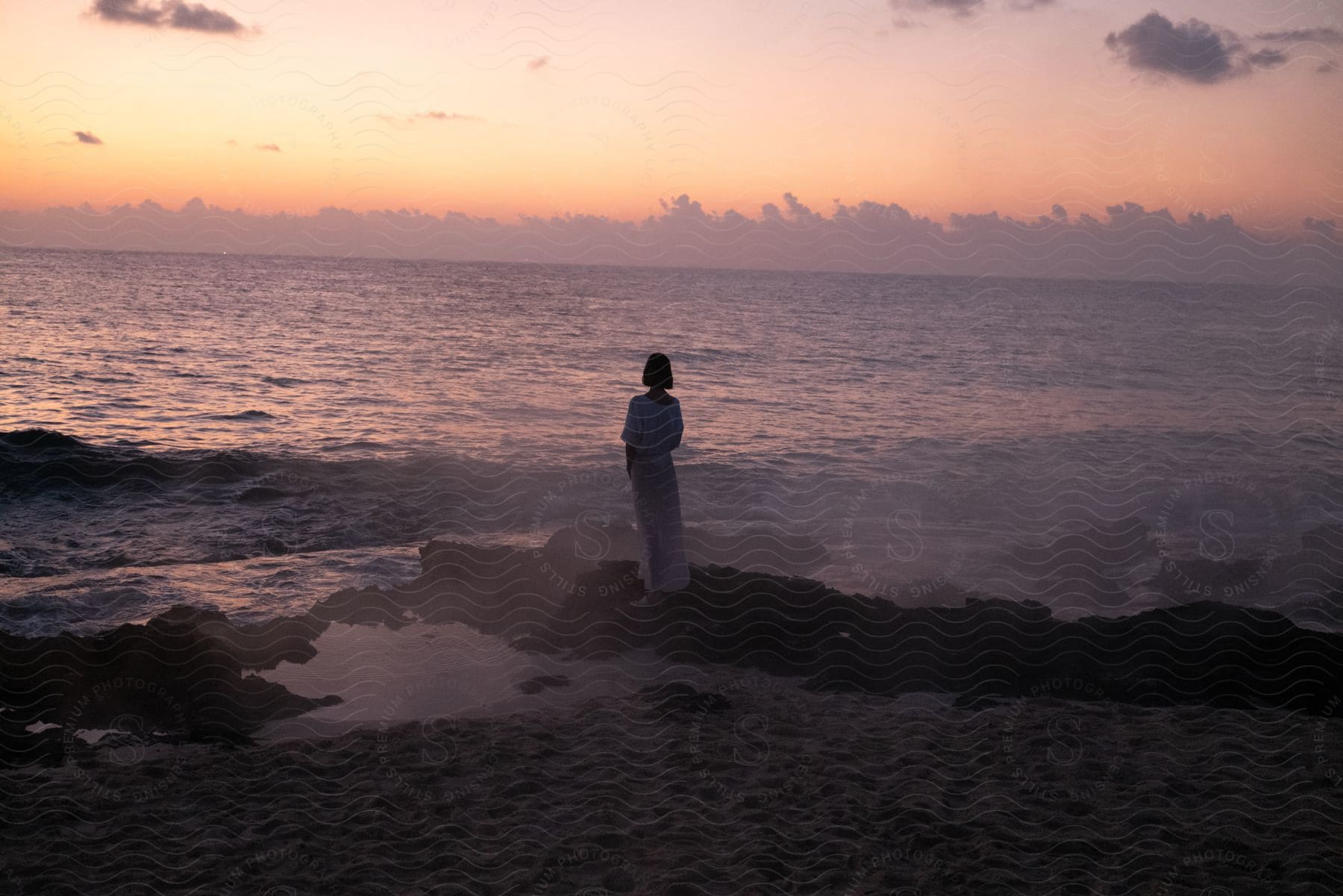 A Woman Is Staring Into The Natural Landscape Watching The Sunset On The Beach