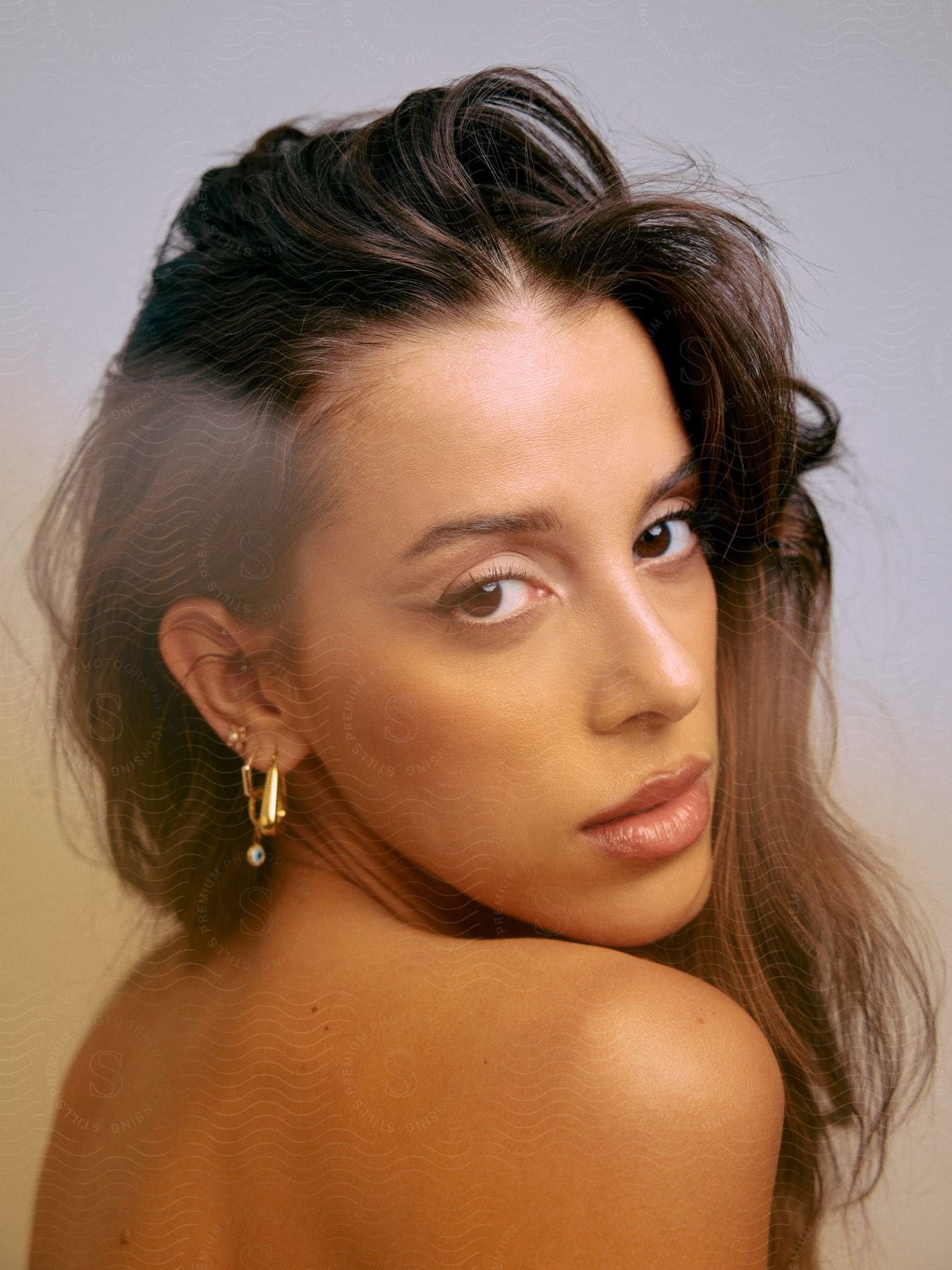 Close up of woman looking over her bare shoulder.