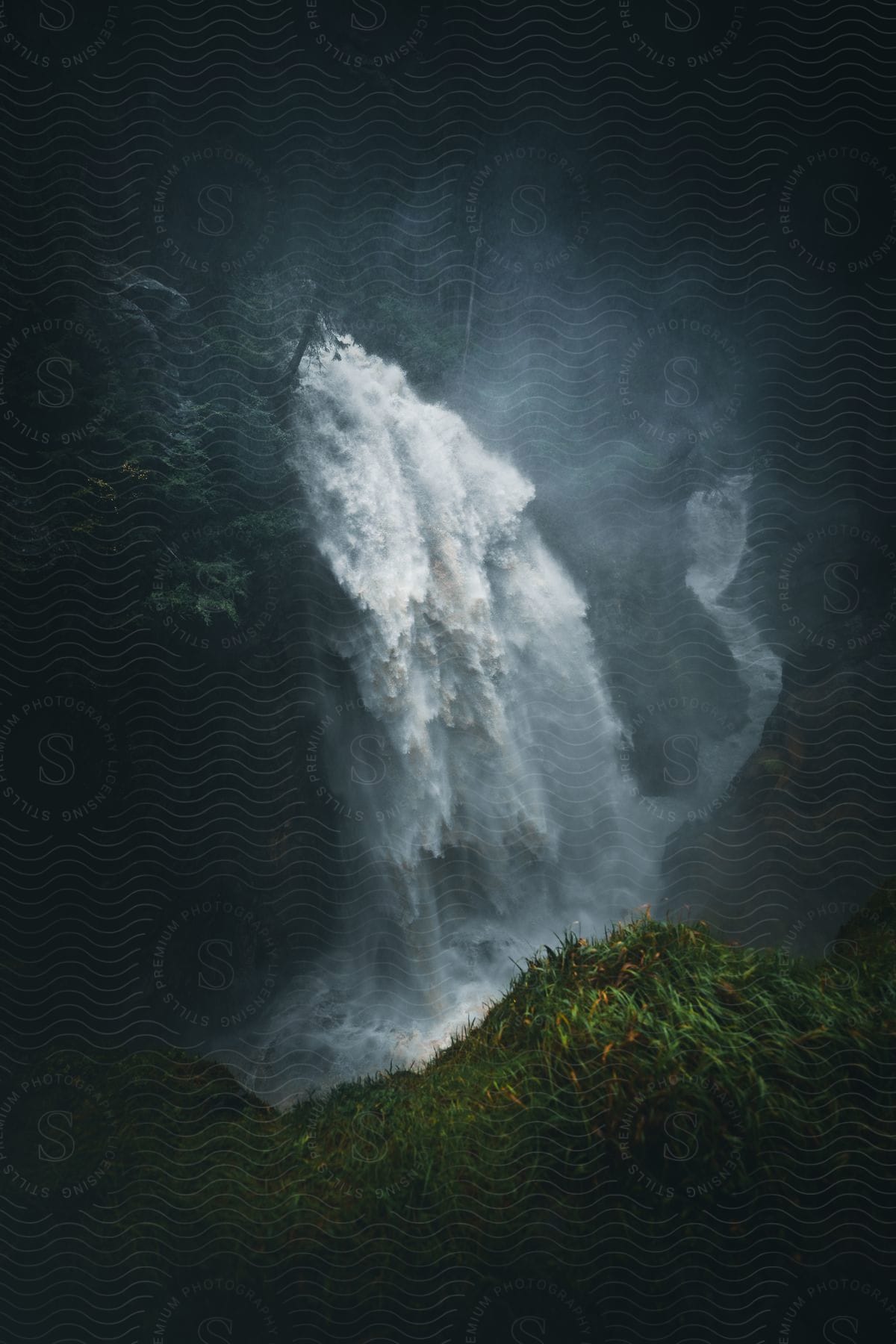 aerial view of a waterfall next to a rocky cliff