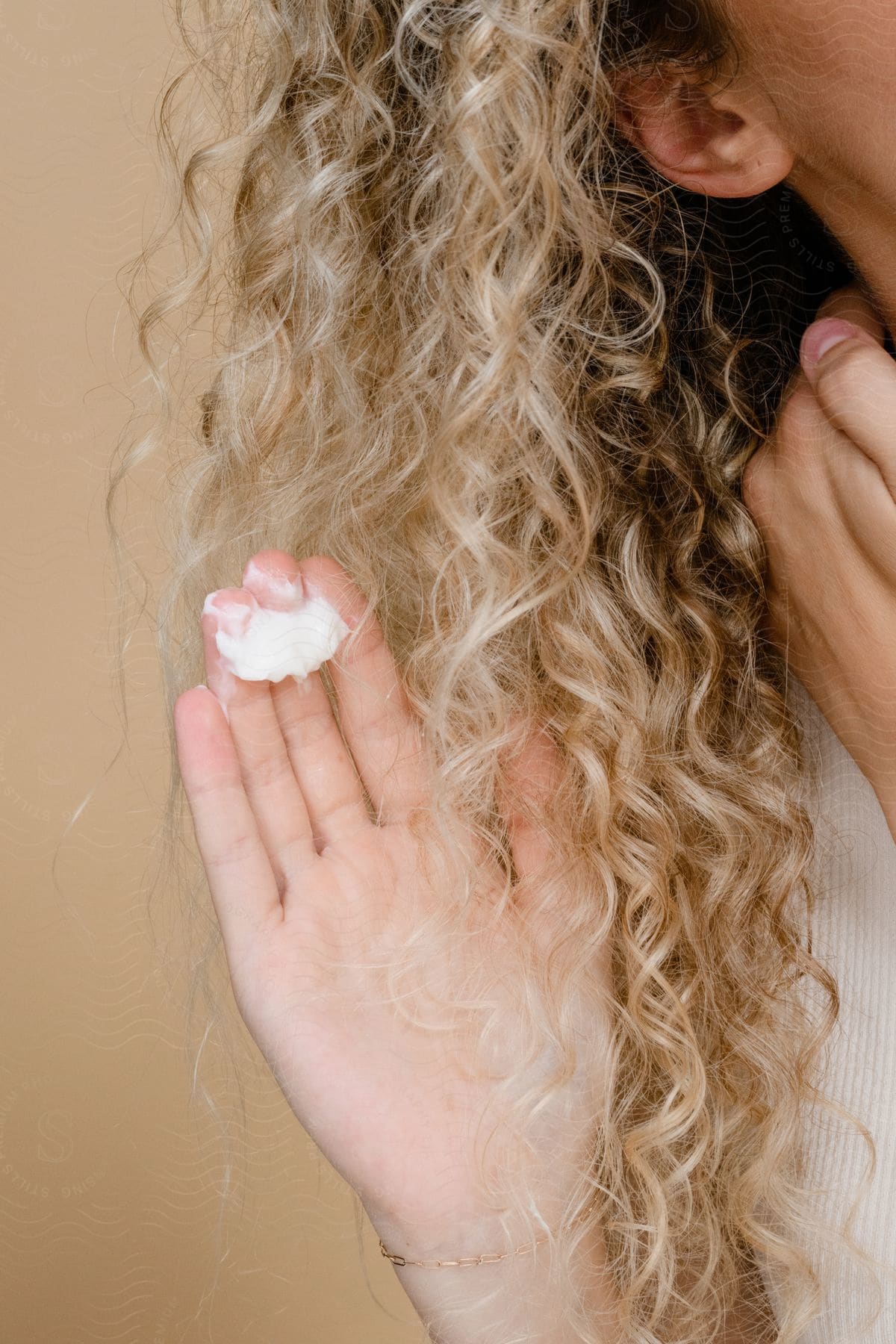 a woman applies mousse to her curly hair