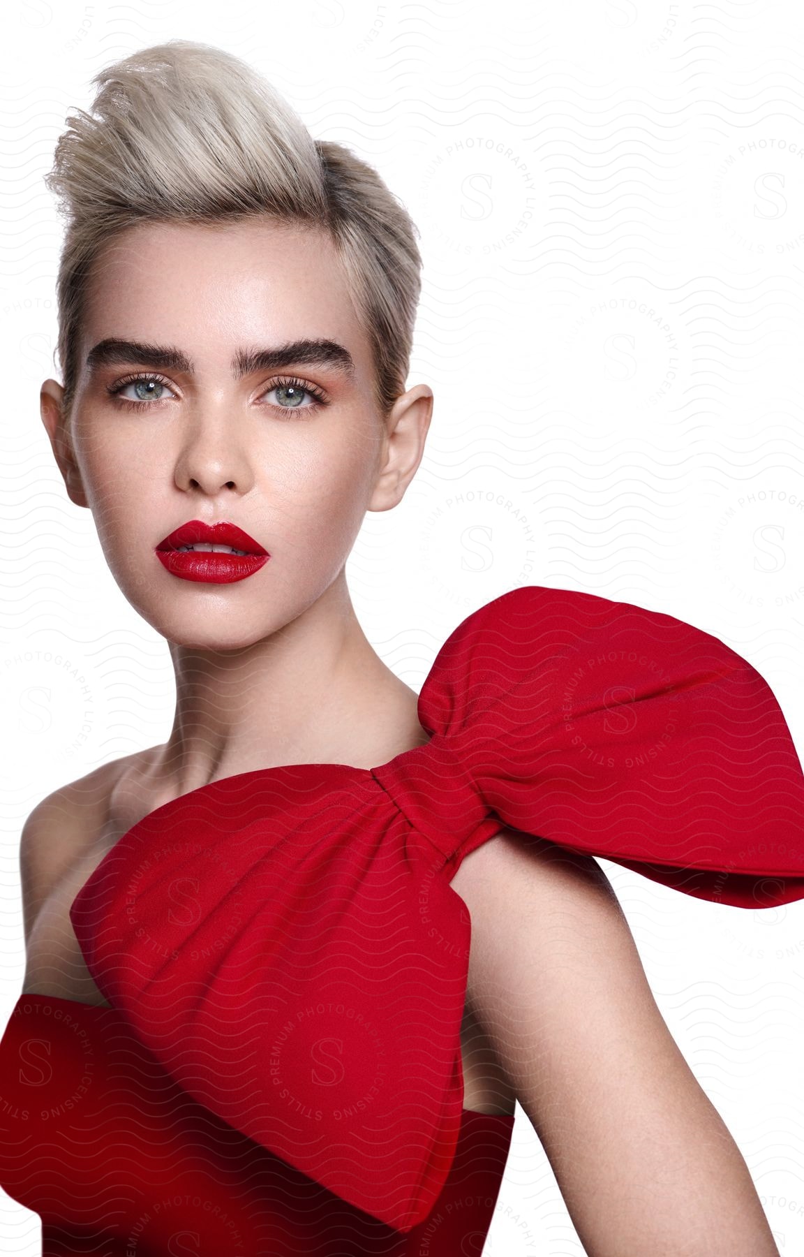 Portrait of a young blonde woman wearing a dress and red lipstick.