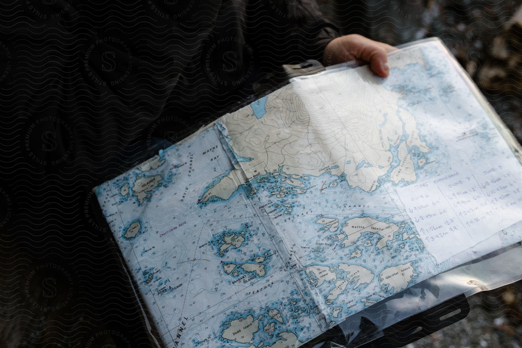 A person in a long-sleeved shirt holds a map in their hand