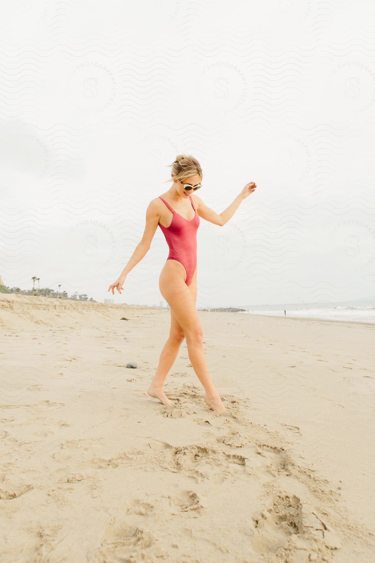 A woman modeling a swimsuit out on a beach.