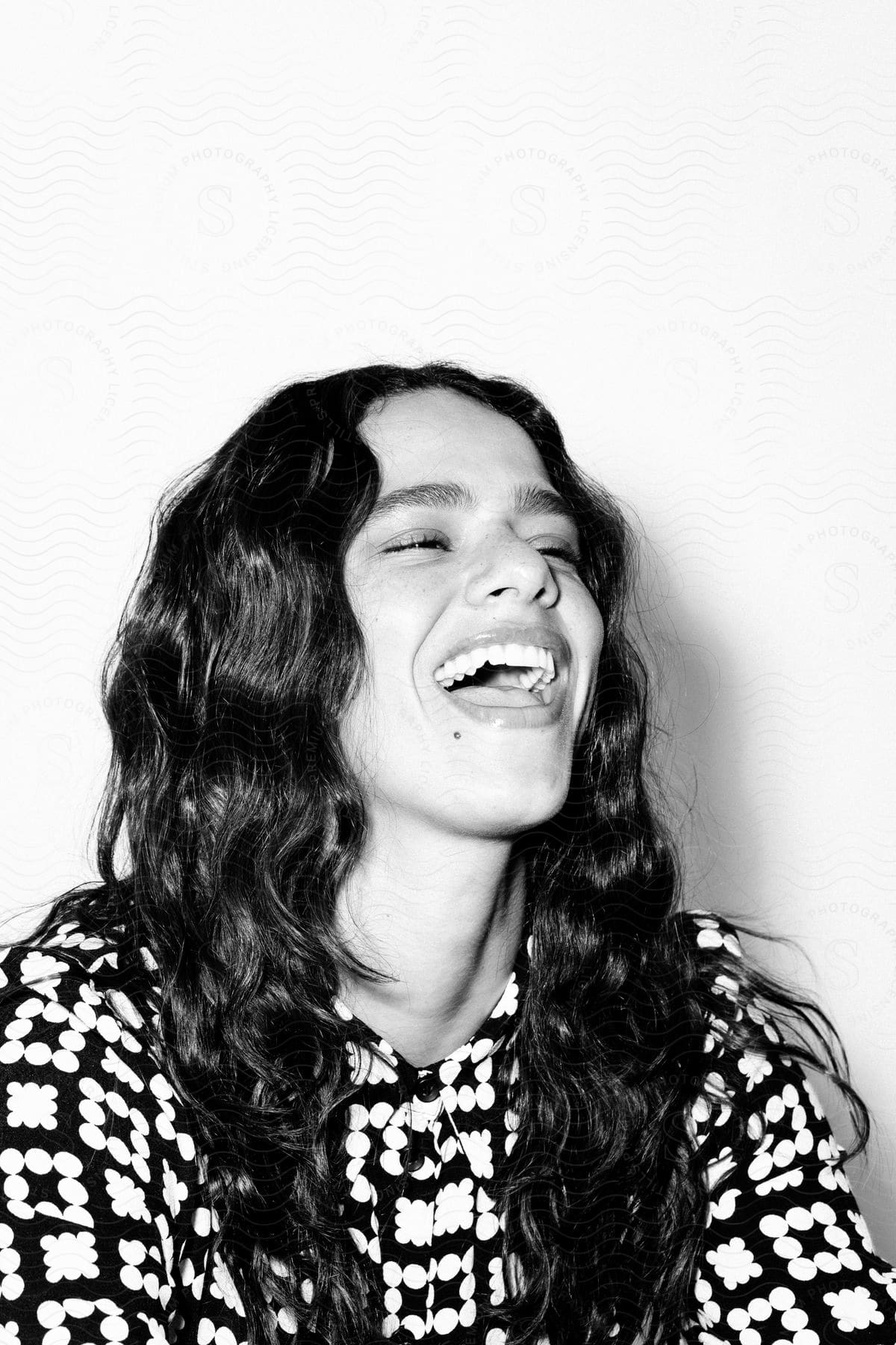 Portrait of a woman laughing while indoors in the daytime.