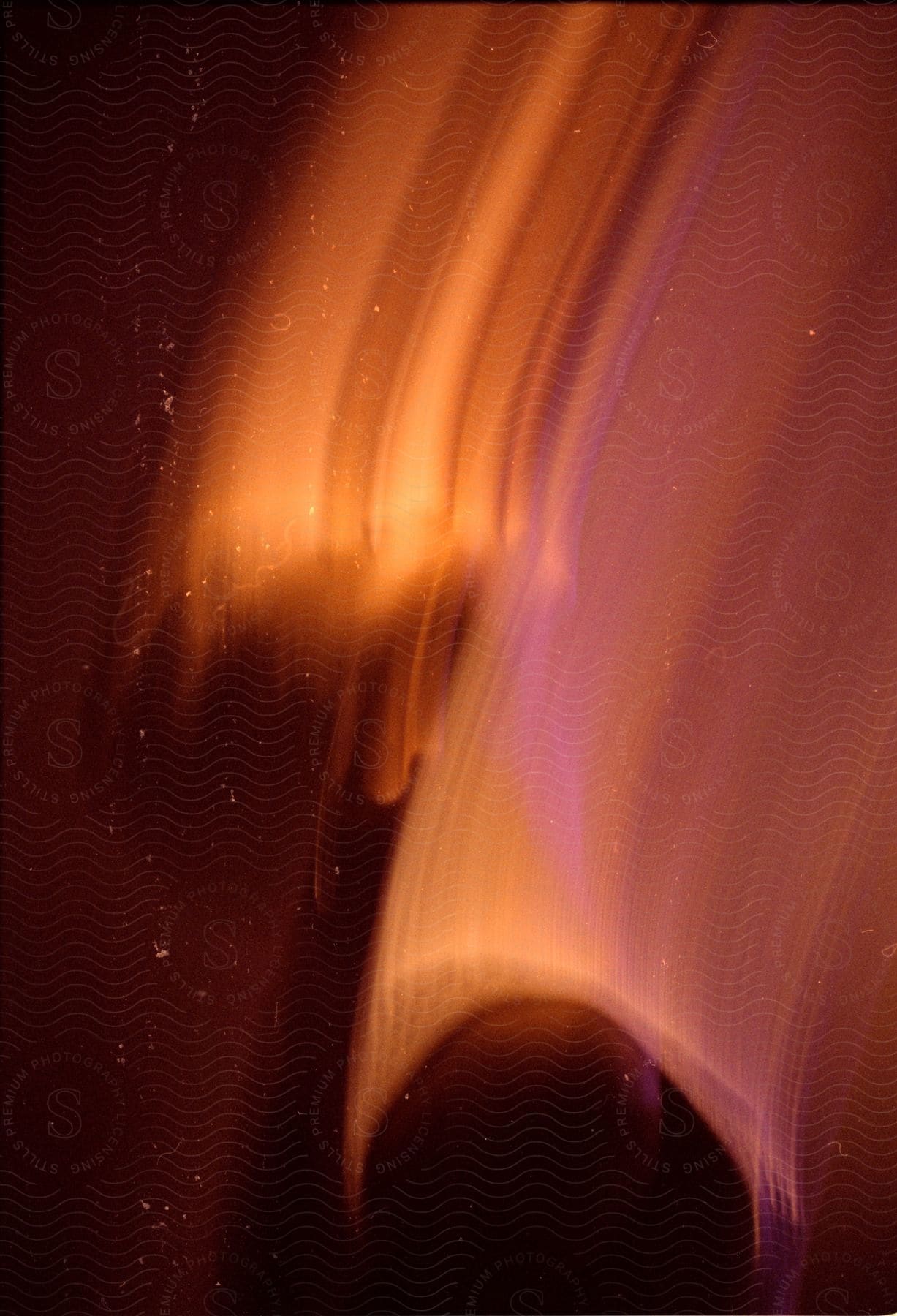 Plasma art of a red and yellow object in the night sky, with motion blur.