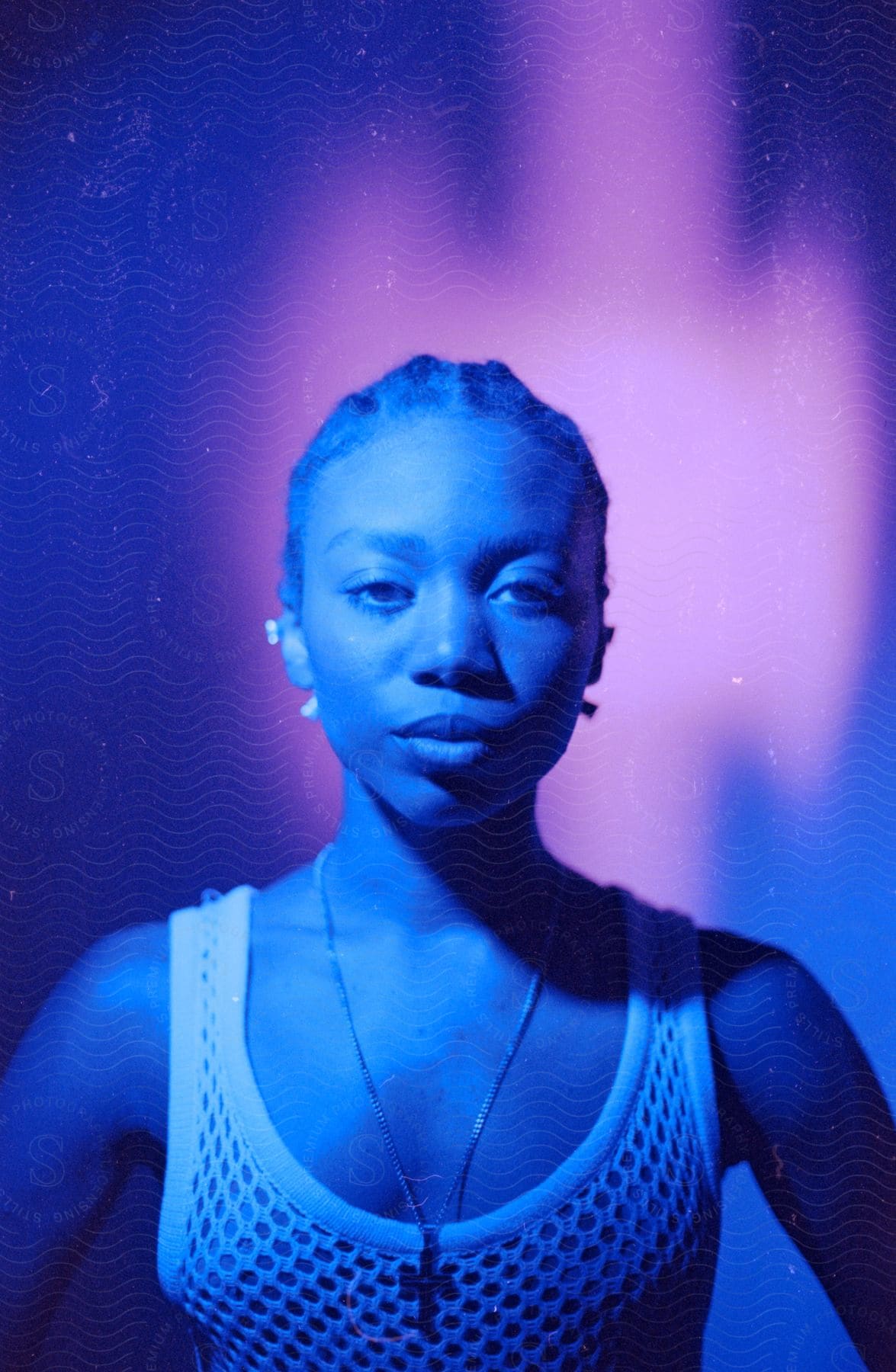 A portrait of a woman with harsh colored lighting in a studio.