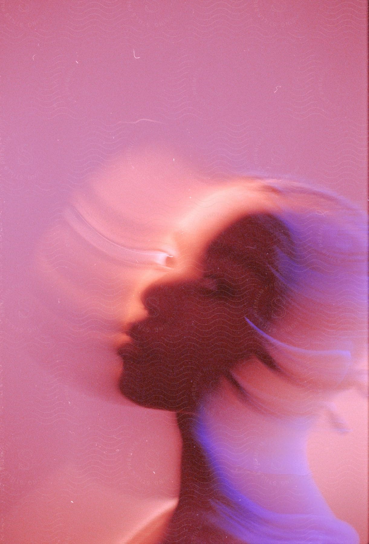 A women is staring as her head is blurred in a motion as she is disappearing.