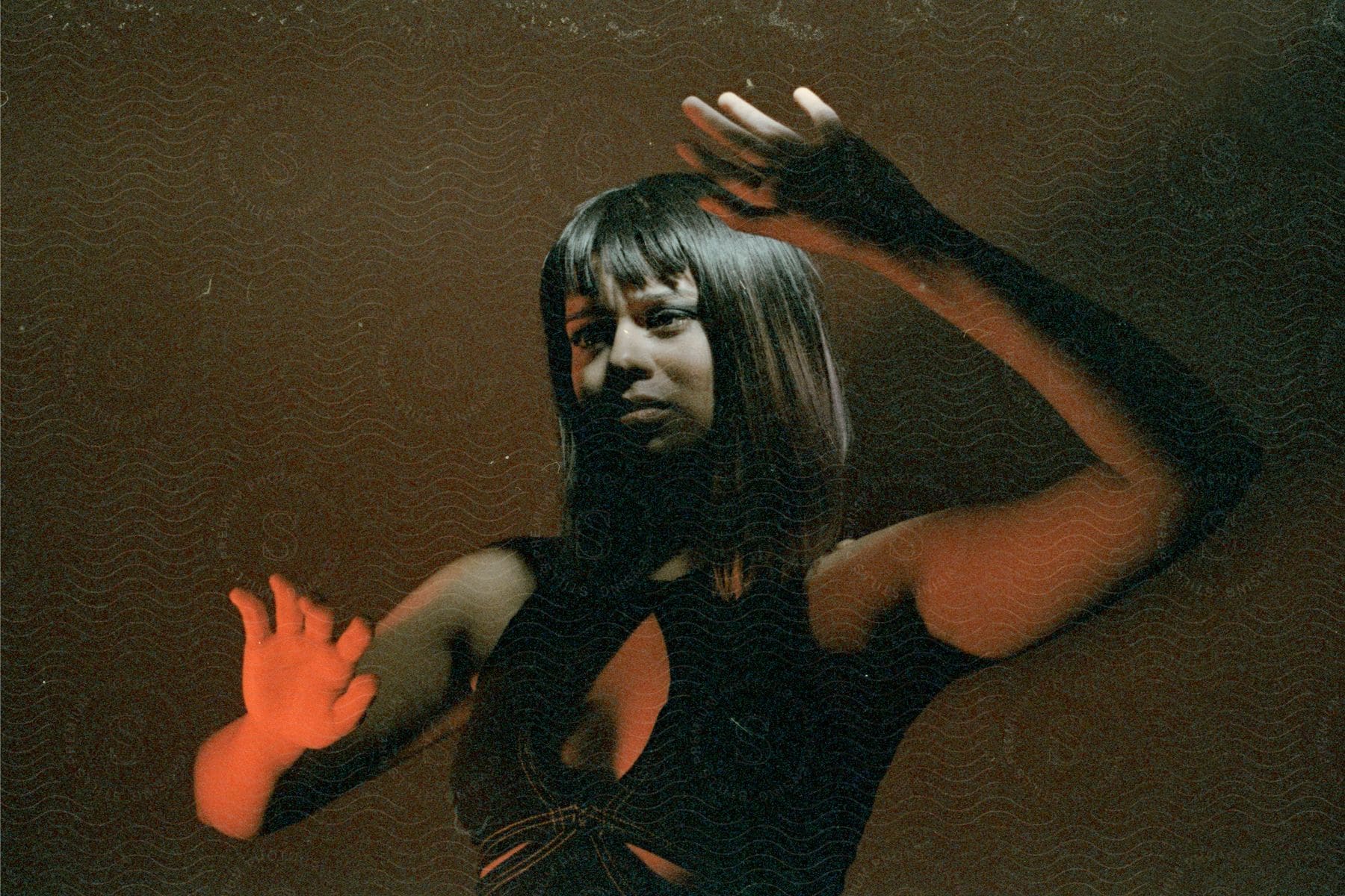 A portrait of a woman in a studio with a brown background.