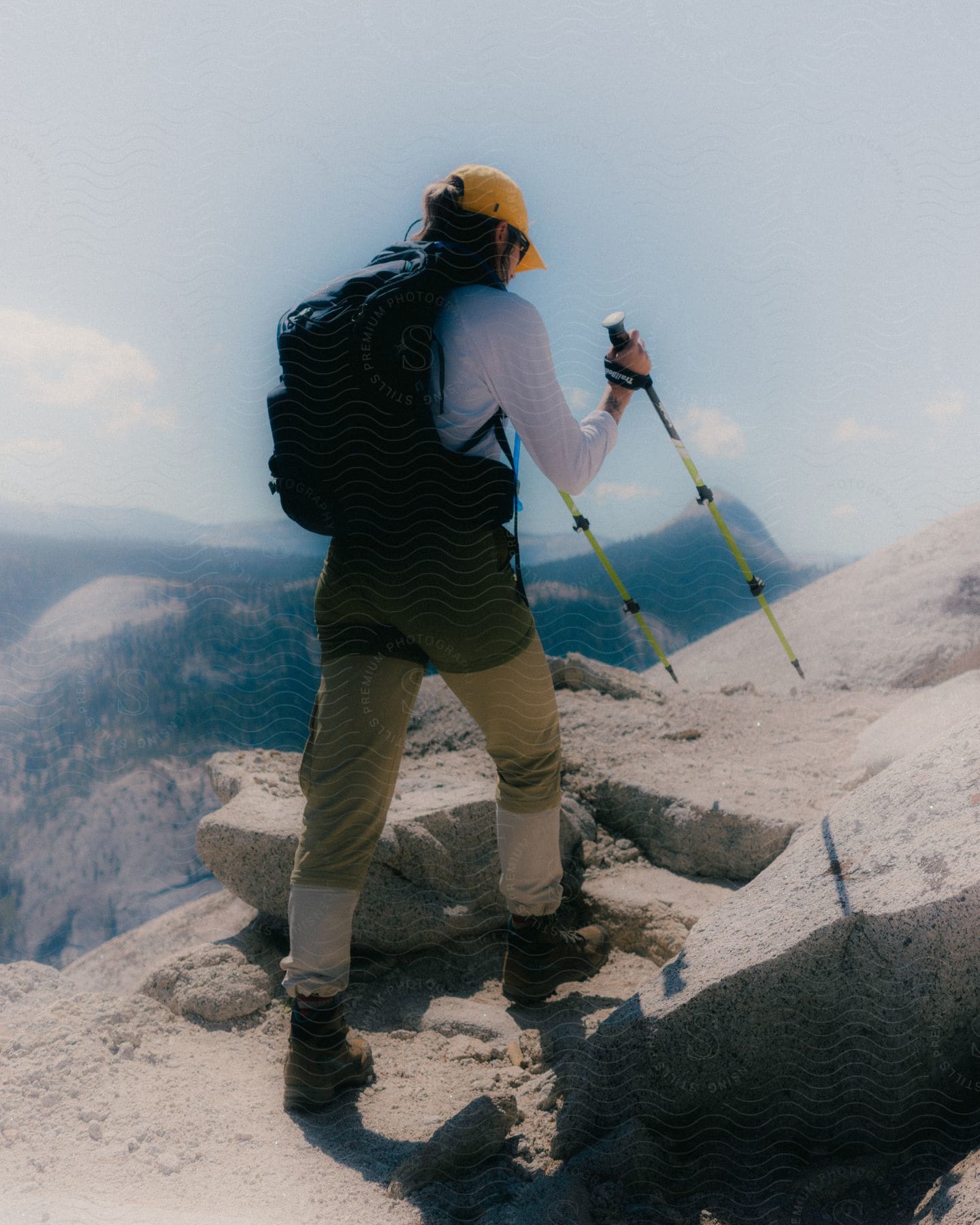 A woman hiking along the top of a cliff