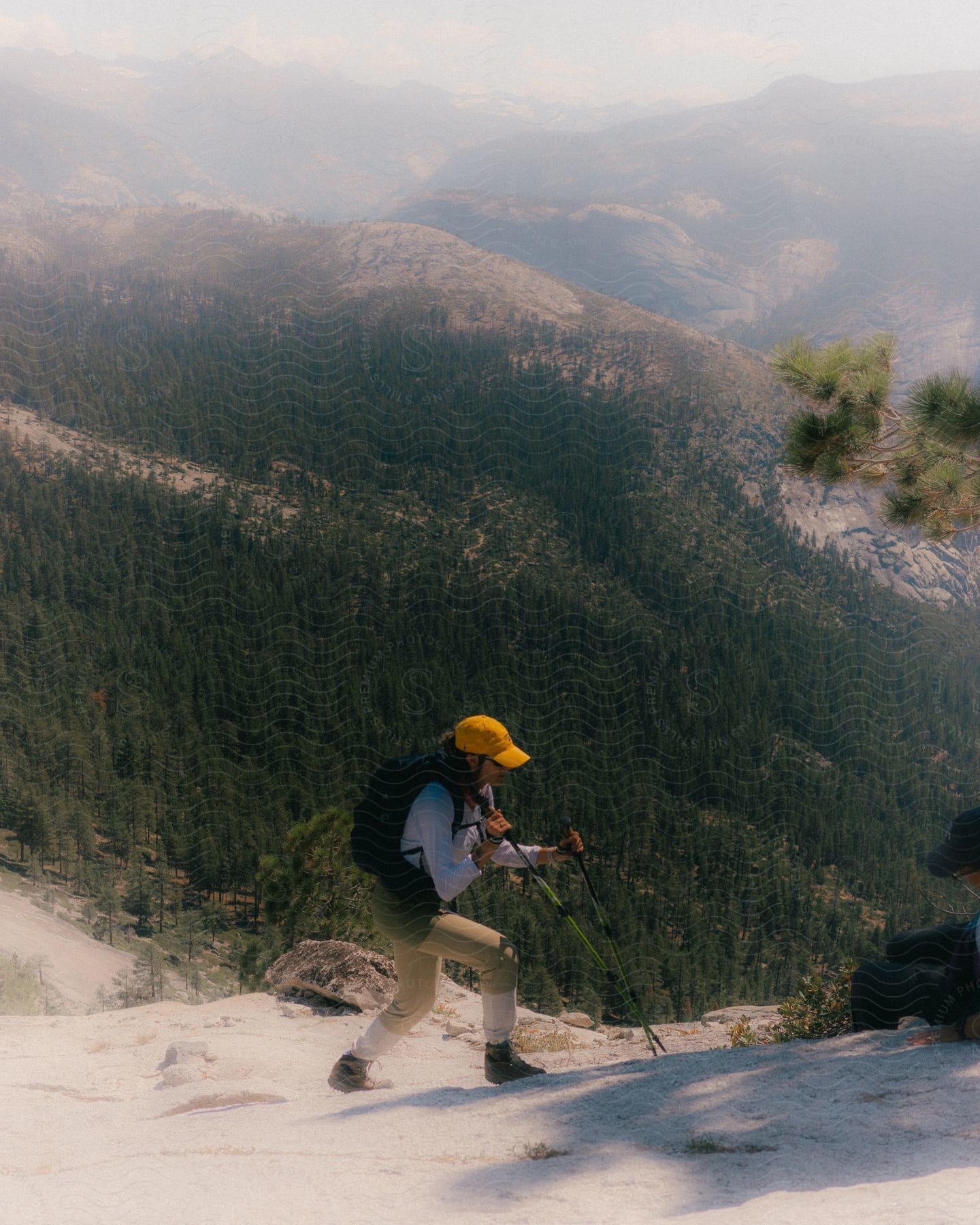 A person is using walking sticks to hike up the mountain.