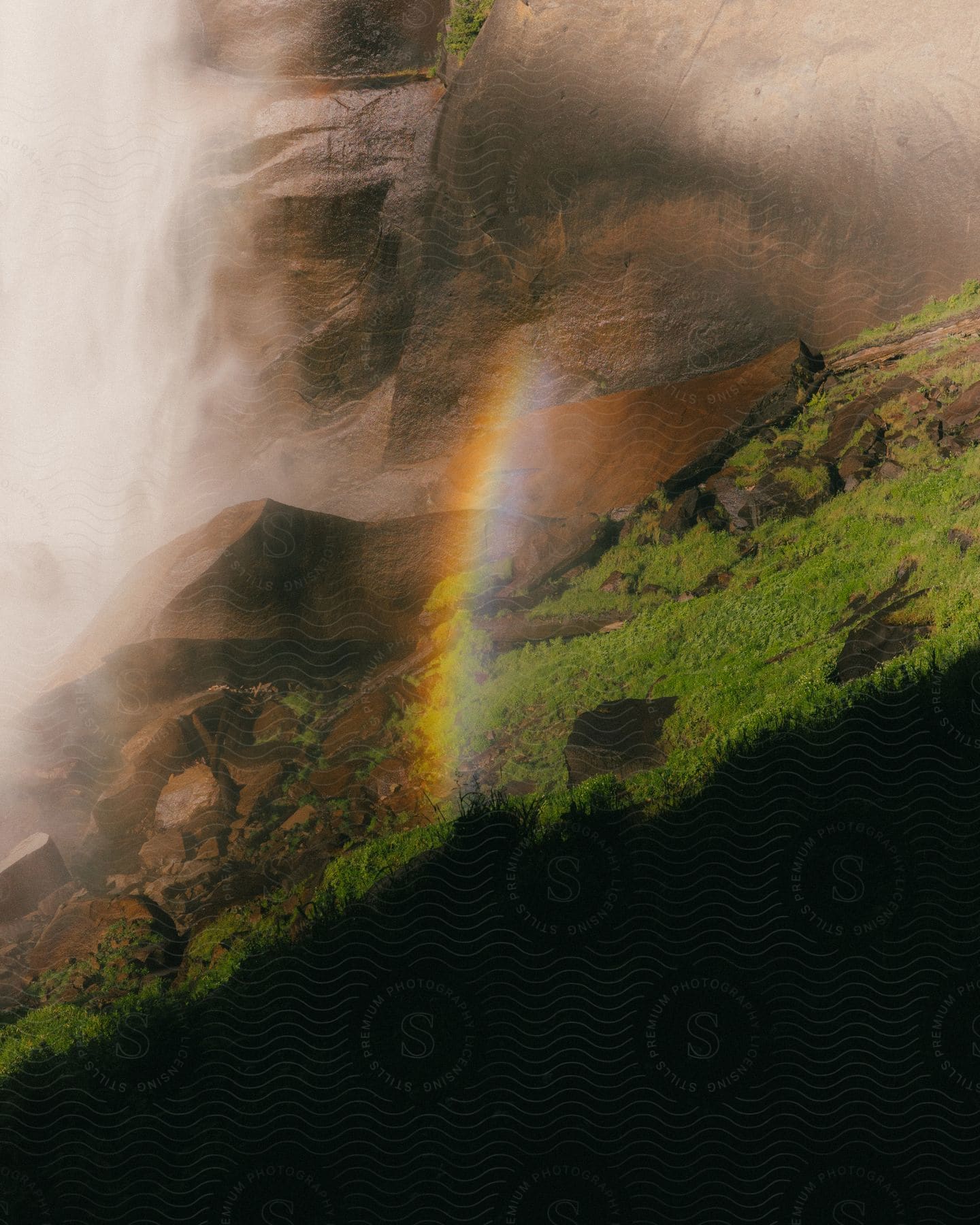 a vivid rainbow arched gracefully over the lush green mountain slope