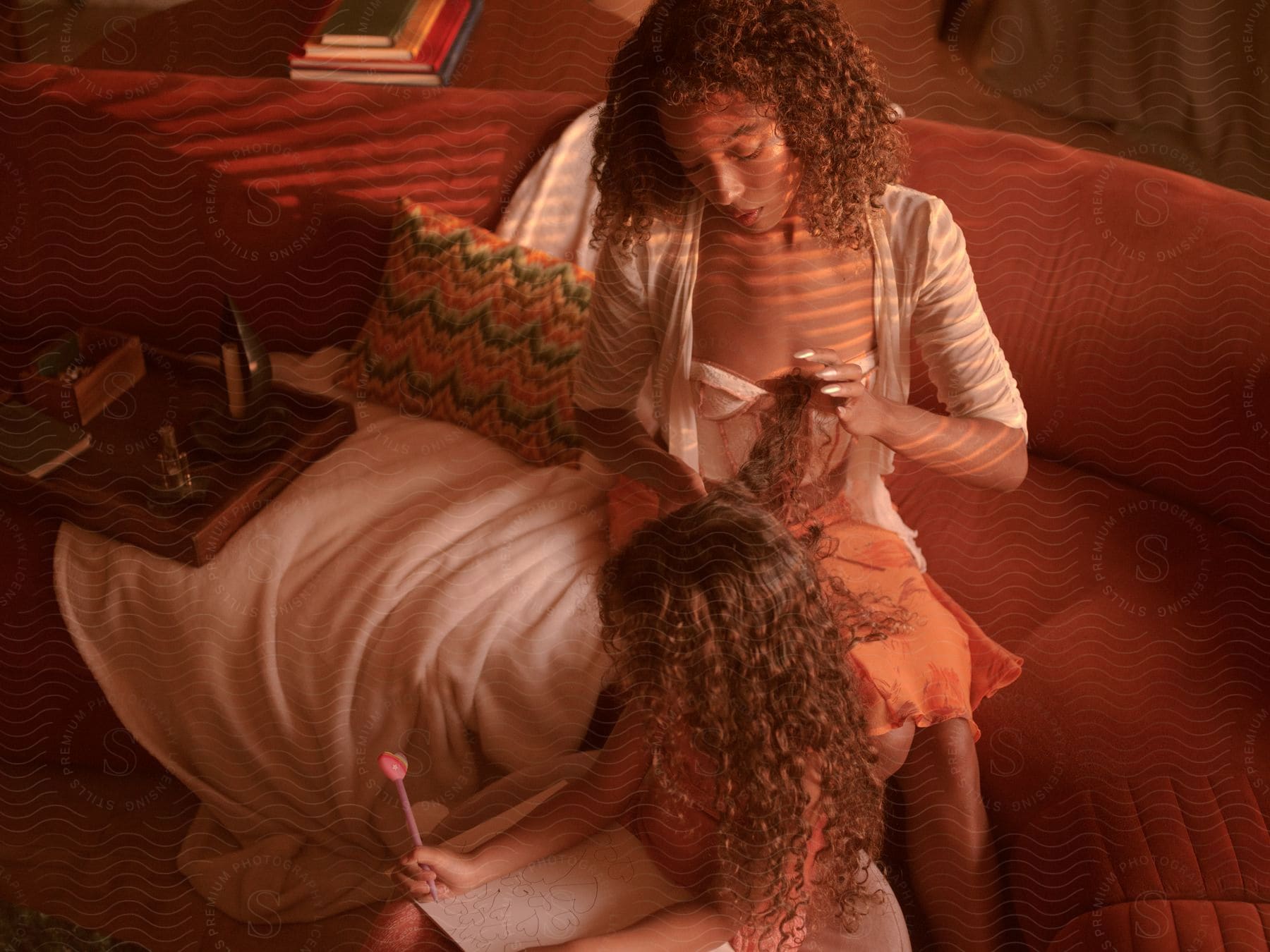 a woman brushes her daughter's curly hair