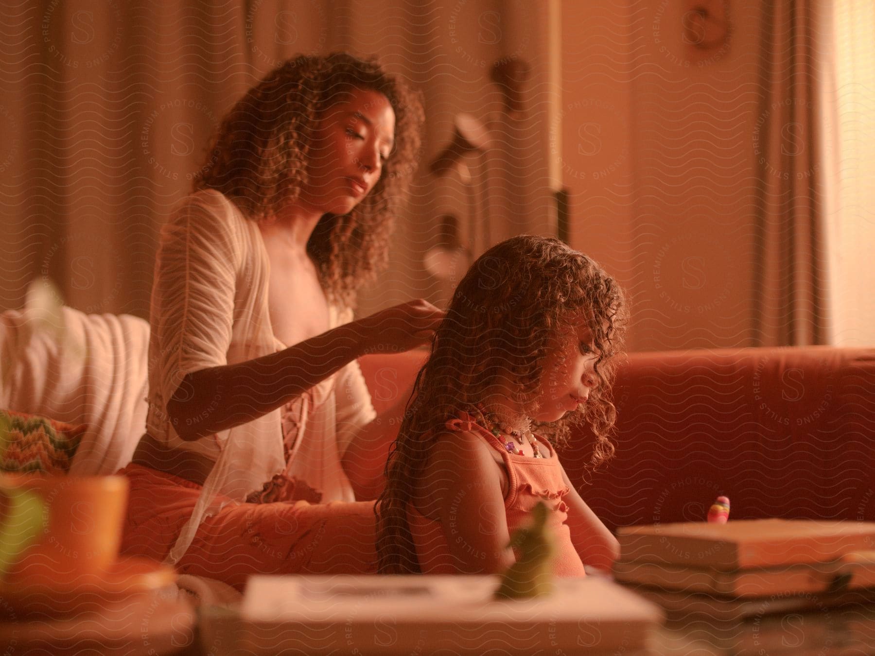 a woman brushes her daughter's curly hair