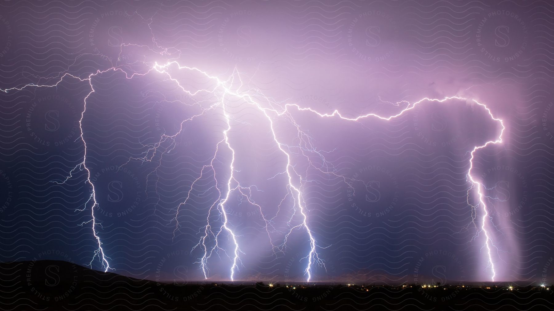 Lightning strikes against purple night sky