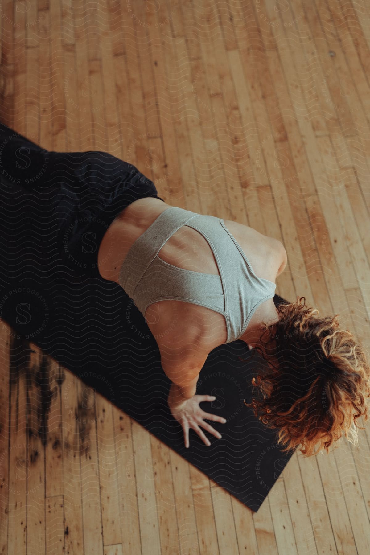 a young lady doing high plank exercise on a yoga mat on the floor