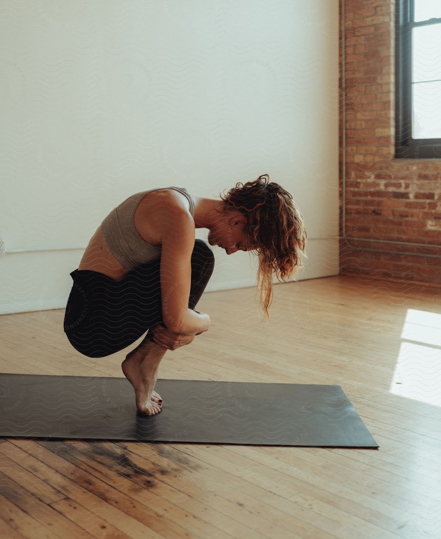 A woman in crouching yoga pose.