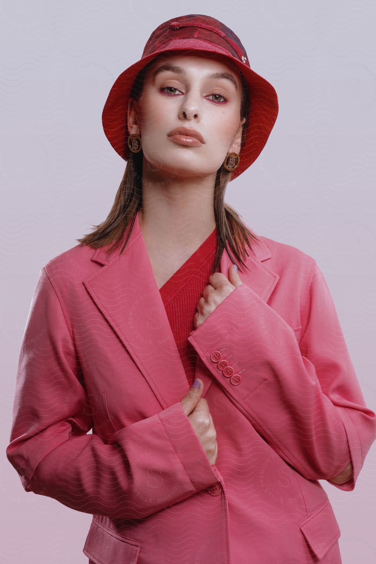 A women is posing in a pink blazer and pink makeup on.