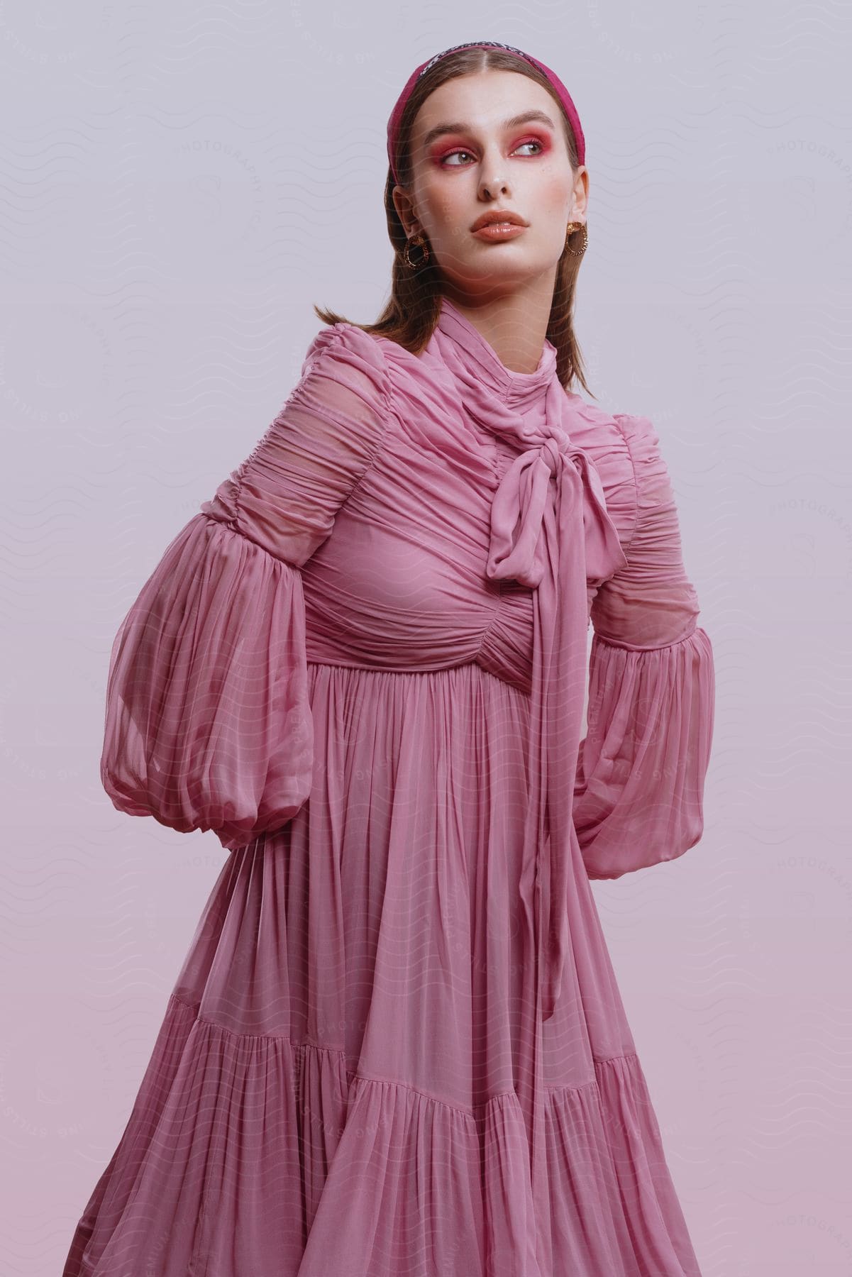 A woman models a pink pleated and ruched dress