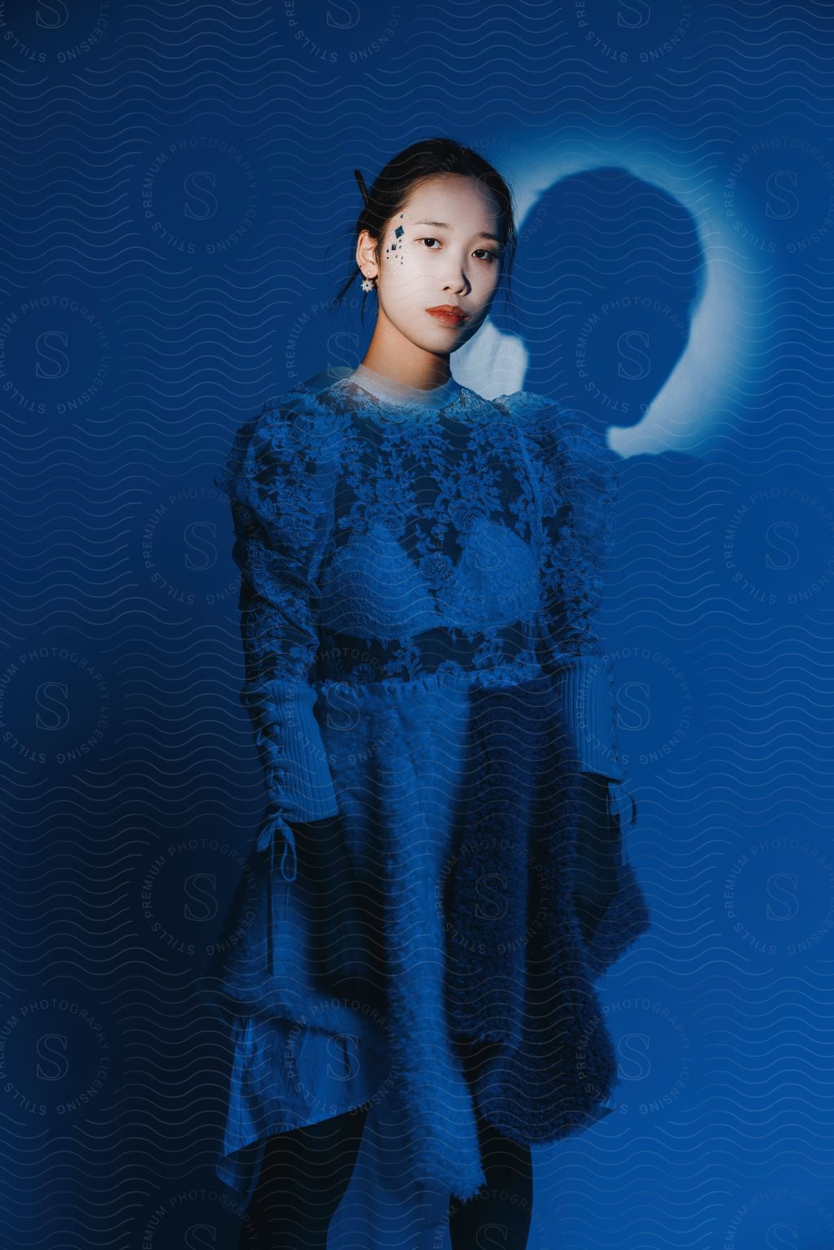 A young Asian woman in different clothes is posing and having her face illuminated.