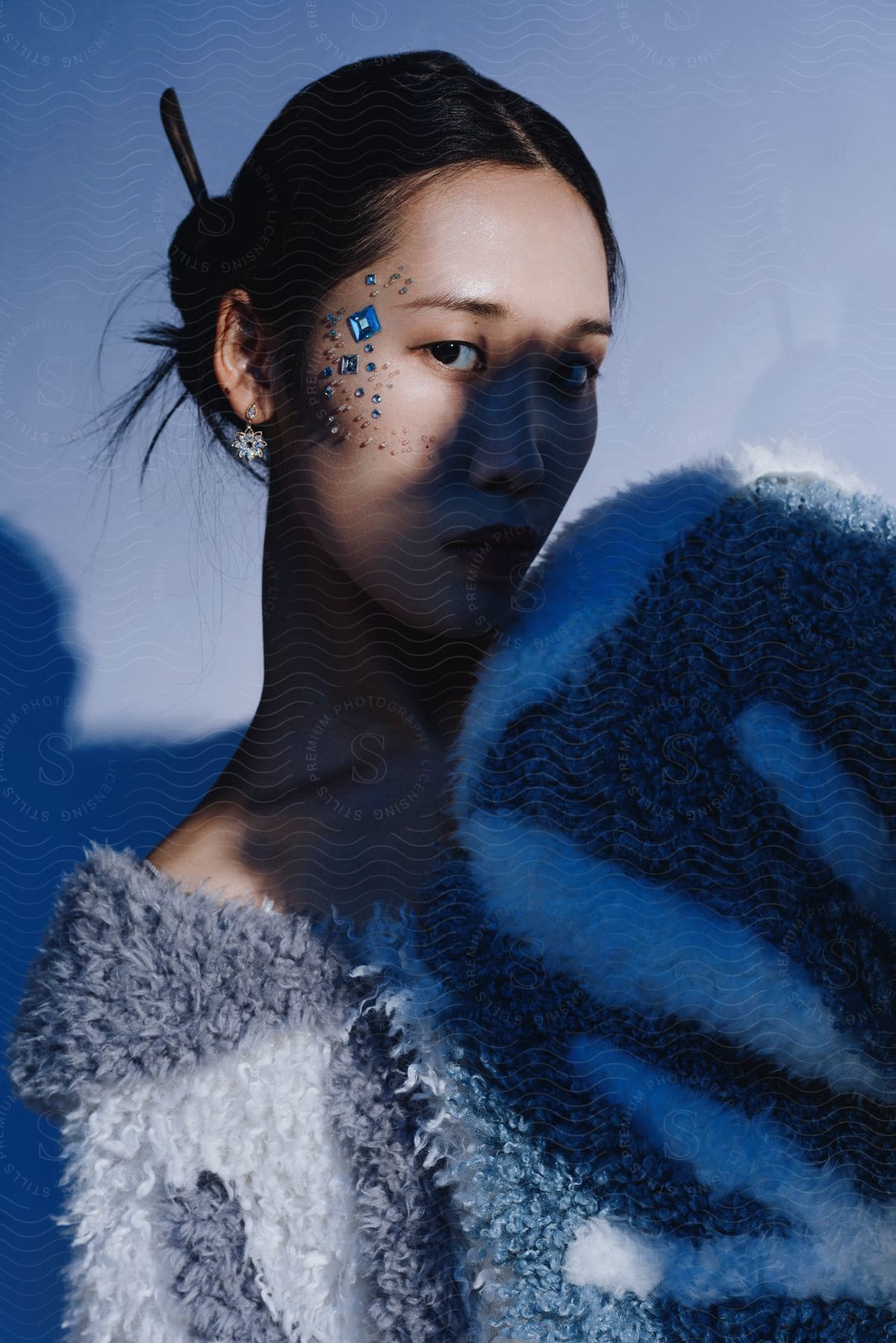 A portrait of a woman wearing clothes with a lot of makeup on standing outdoors.