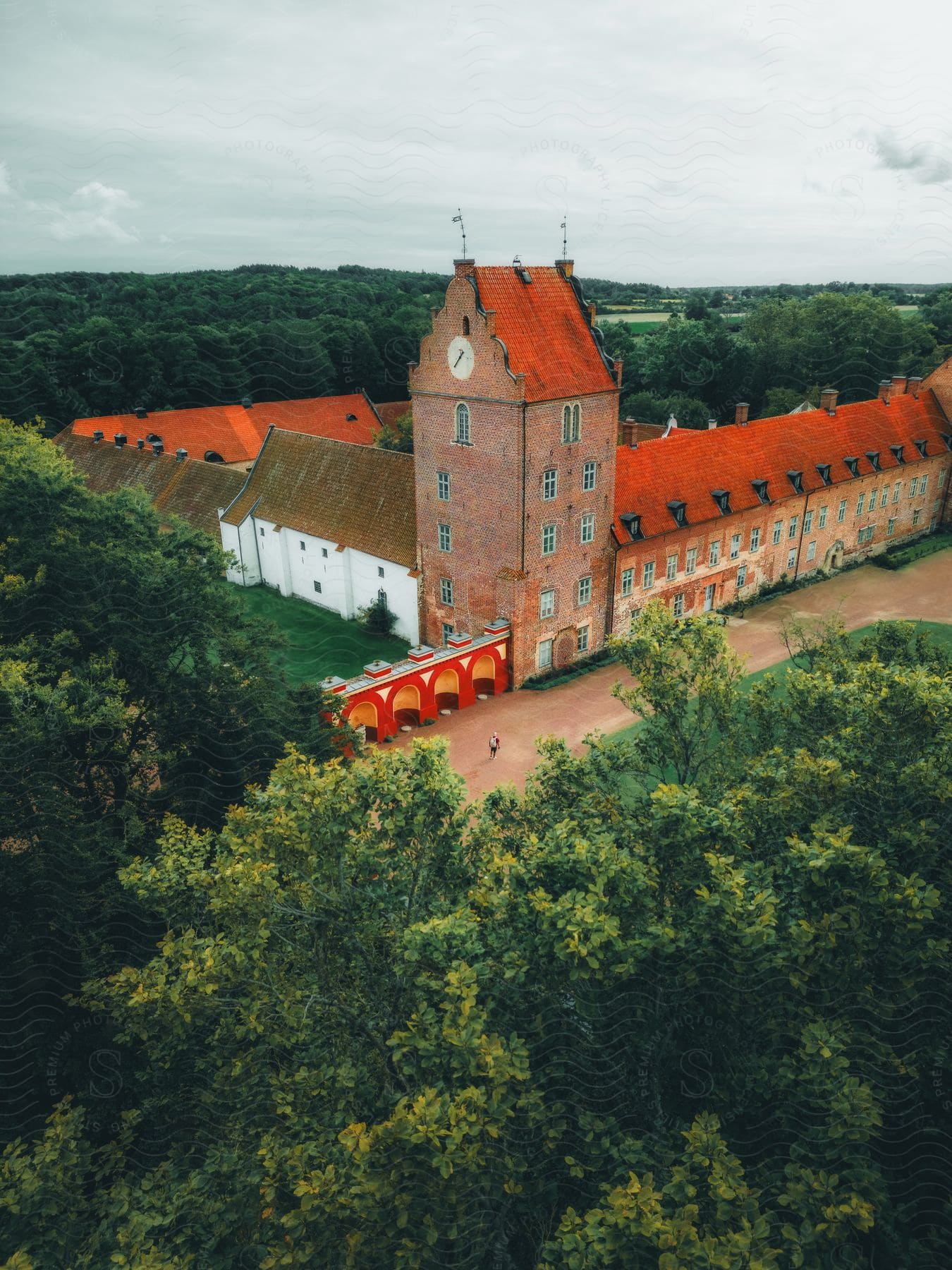 The buildings of a private school sit in a wooded, rural area under cloudy skies.