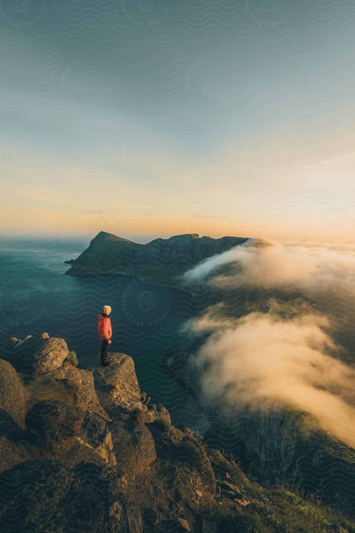 A Lone Figure Stands Atop A Mountain, Gazing At The Endless Expanse Of Ocean And Clouds Below