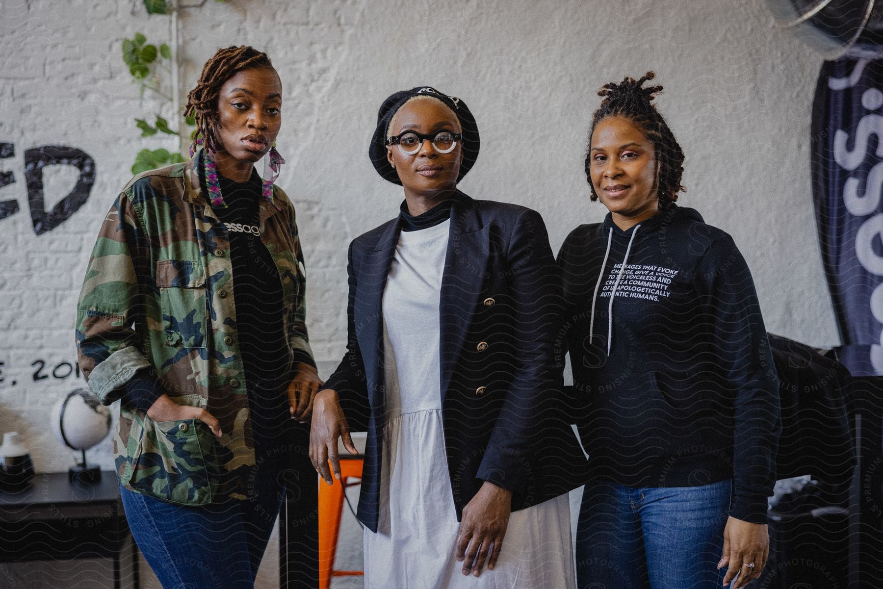 Three women are standing together as they look ahead