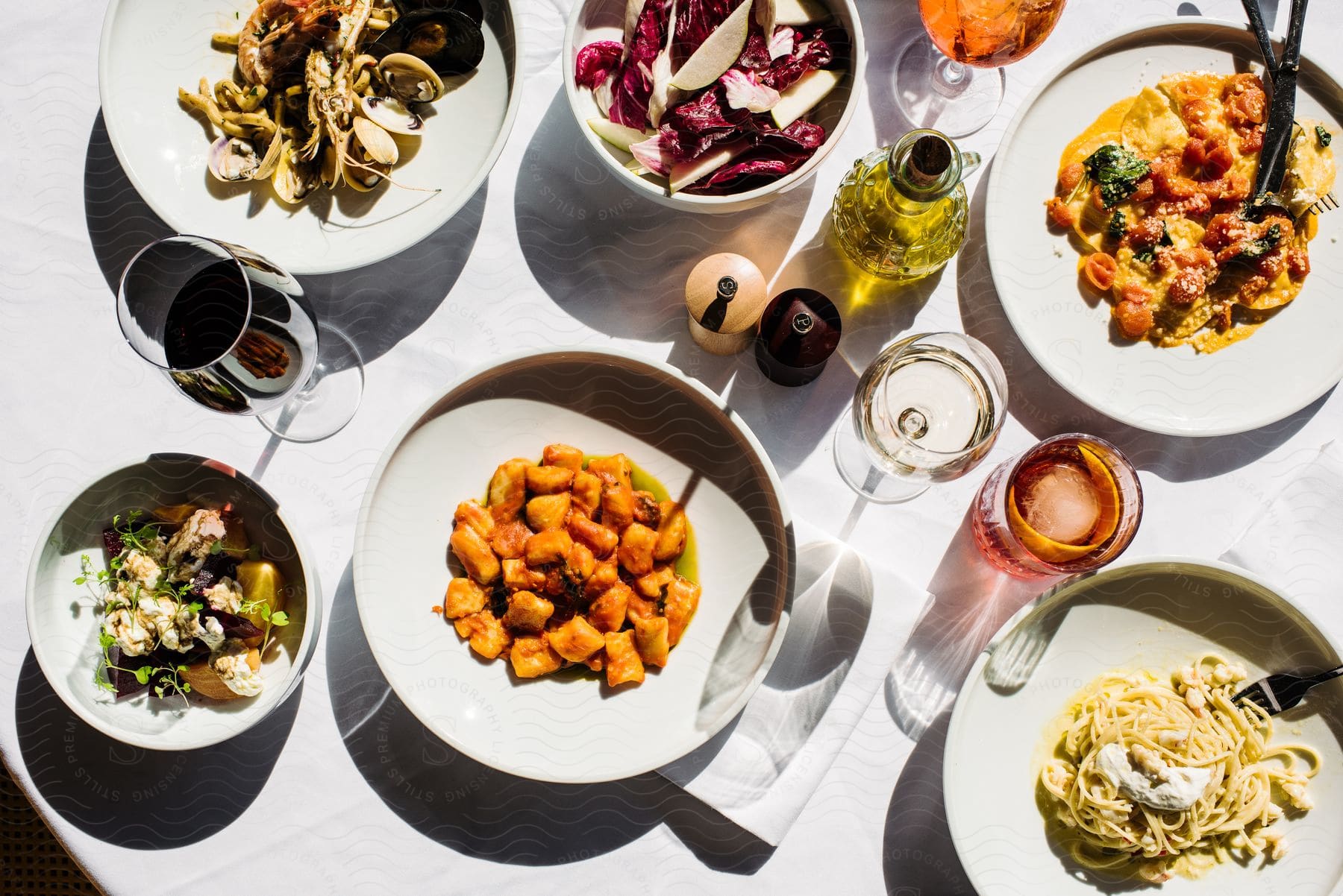 A meal with several pasta dishes and salads.