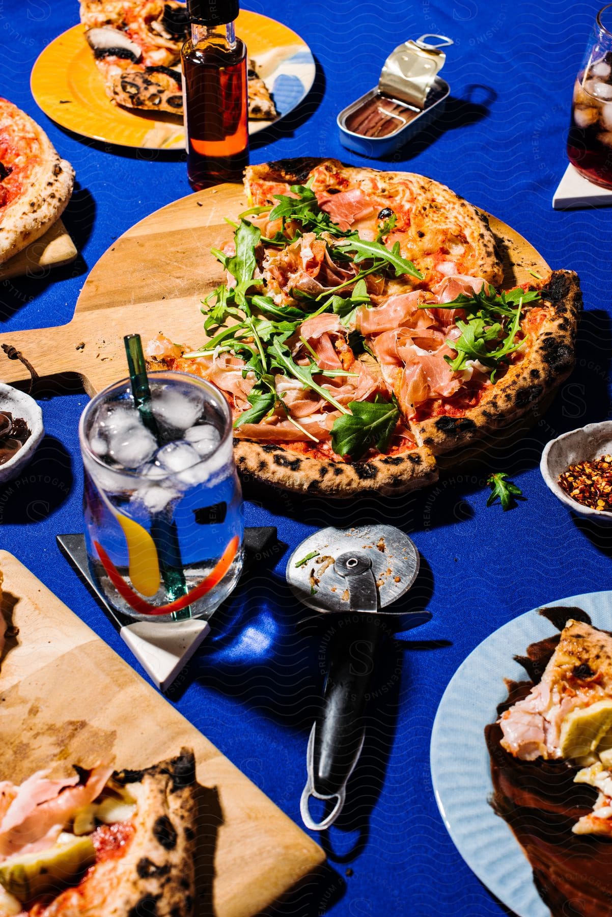 Multiple pizzas on cutting boards are partially cut and placed on plates on a table.