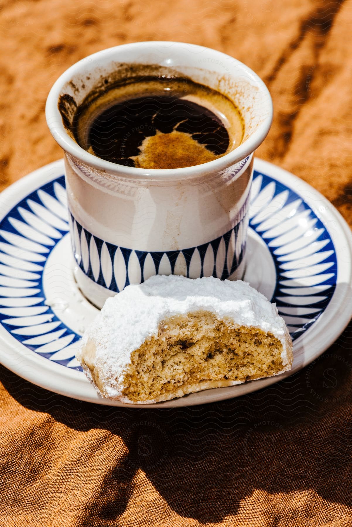 A Cup of coffee next to a partially consumed cookie