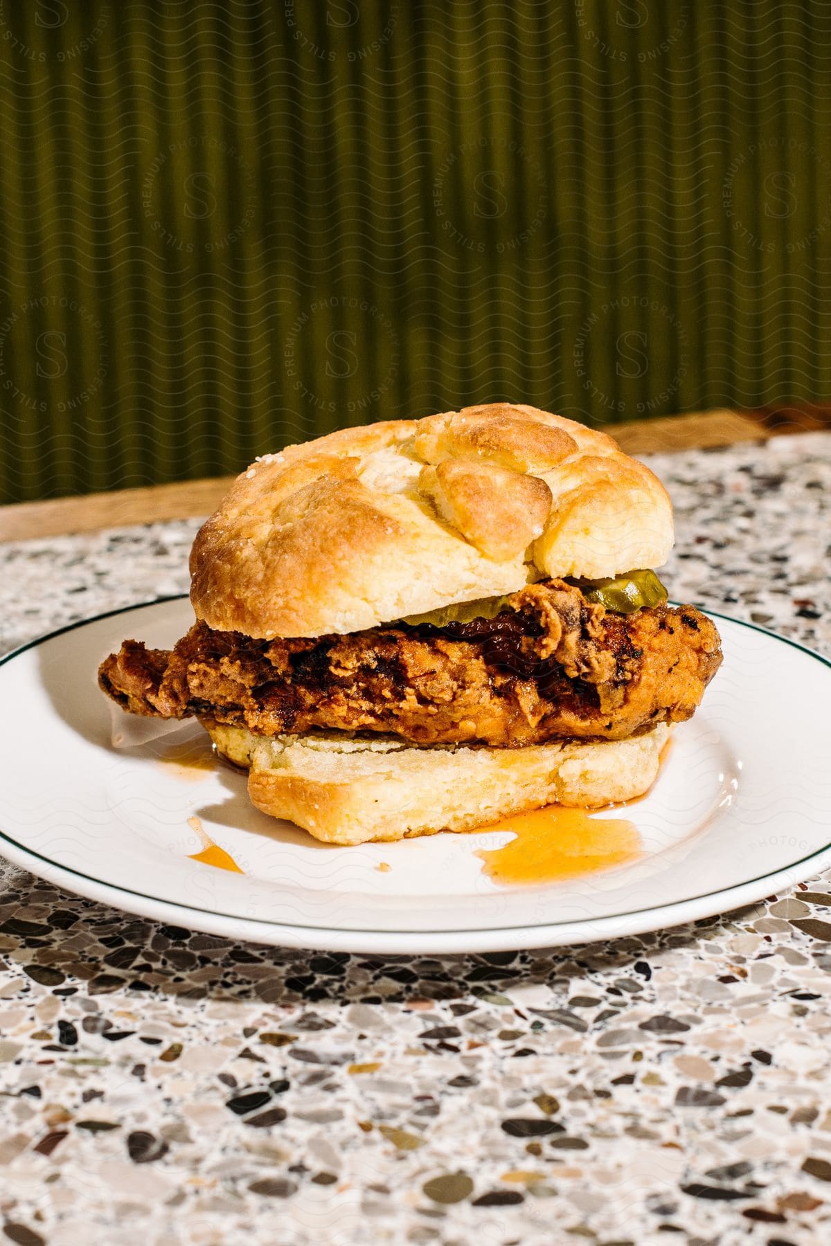 a fried chicken sandwich rests on a small plate