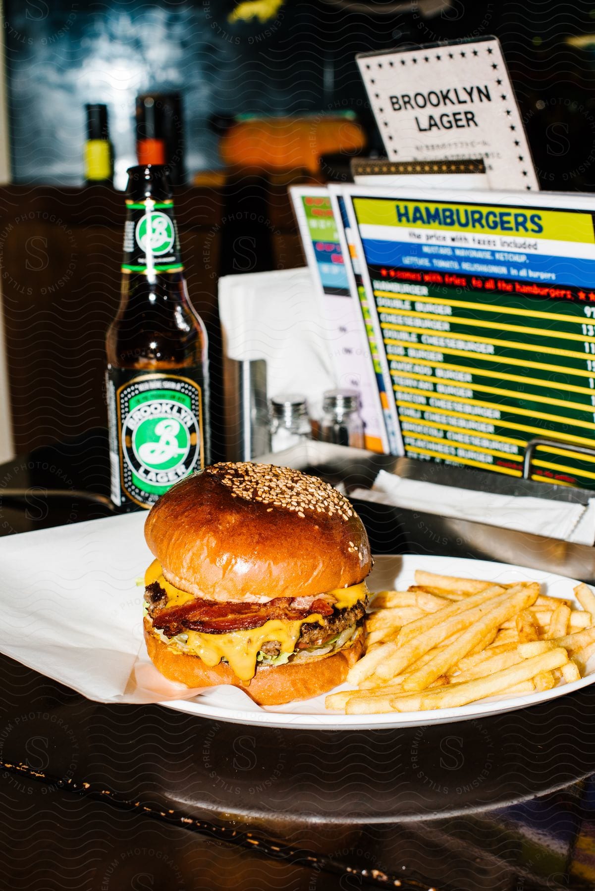 A hamburger, French fries and a beer at a restaurant.