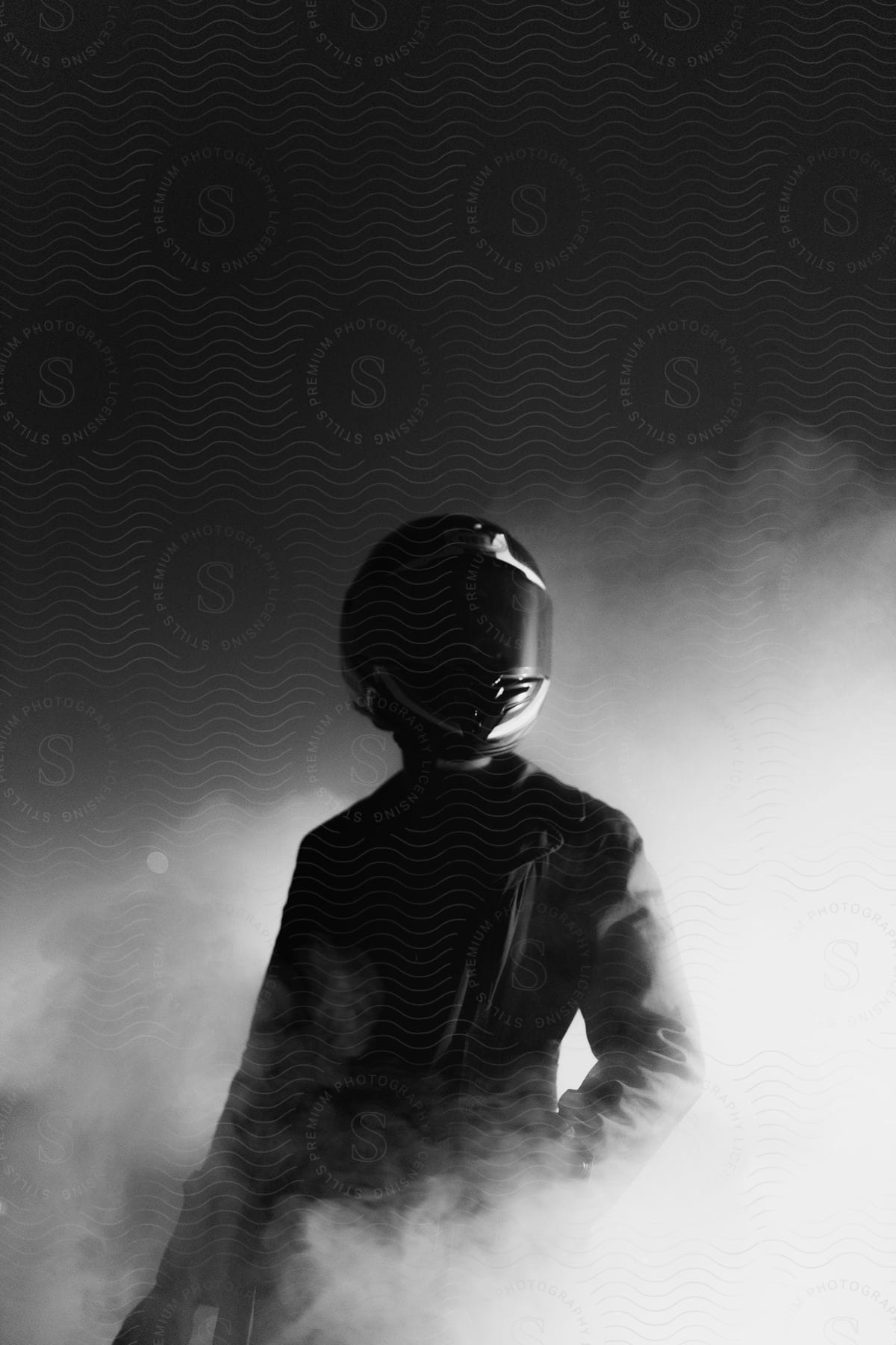 Person wearing black helmet stands in smoke