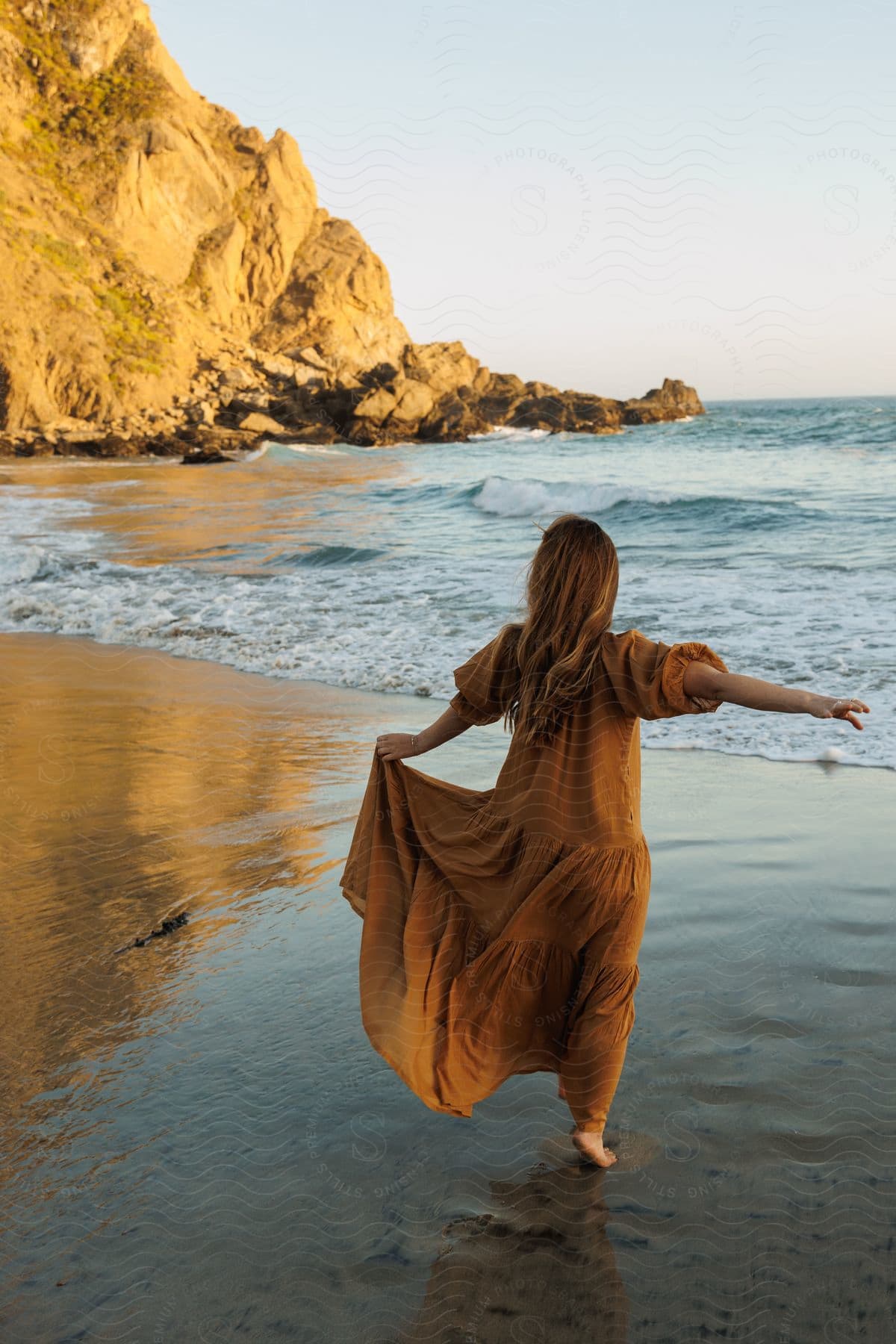 a young lady wearing gown at the beach at mid-day