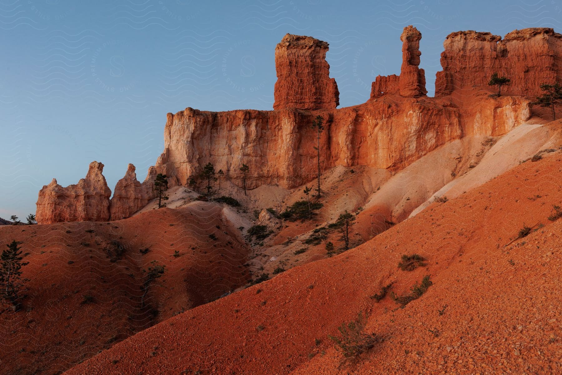 Red rock formations stand high on the desert canyons under a clear sky