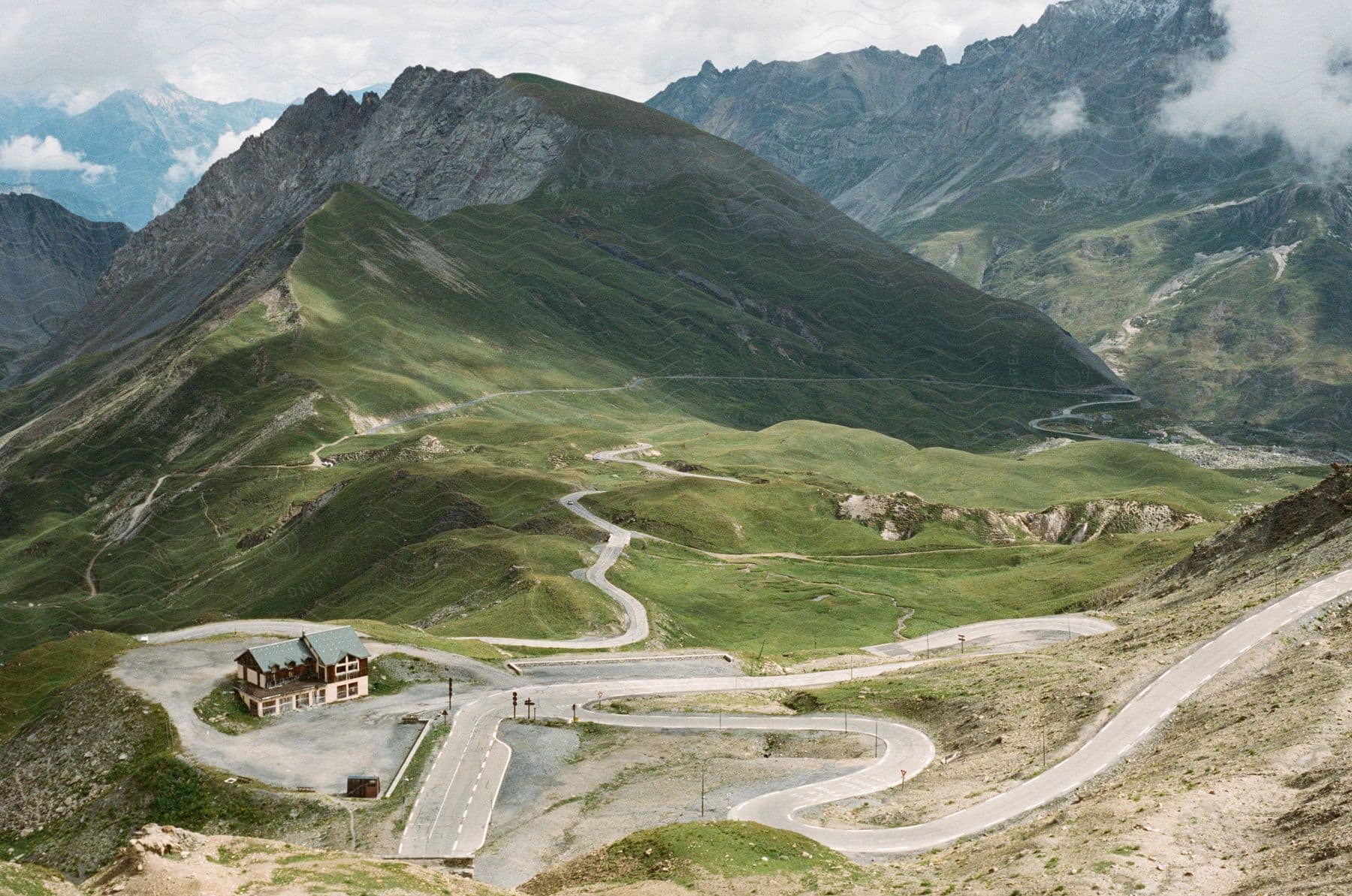 A road winding through the mountains reaching a mountain lodge.