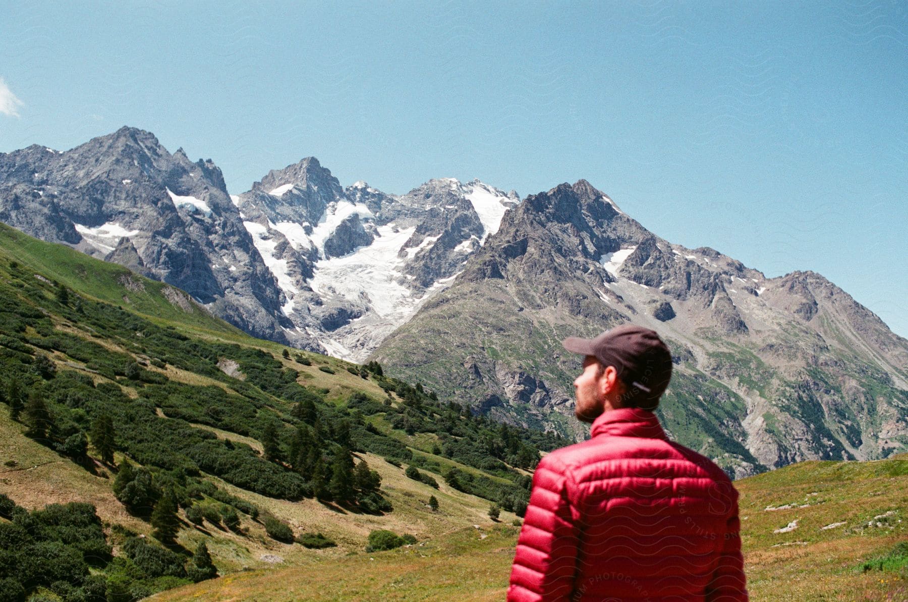 A Man Is Staring Up At The Mountains