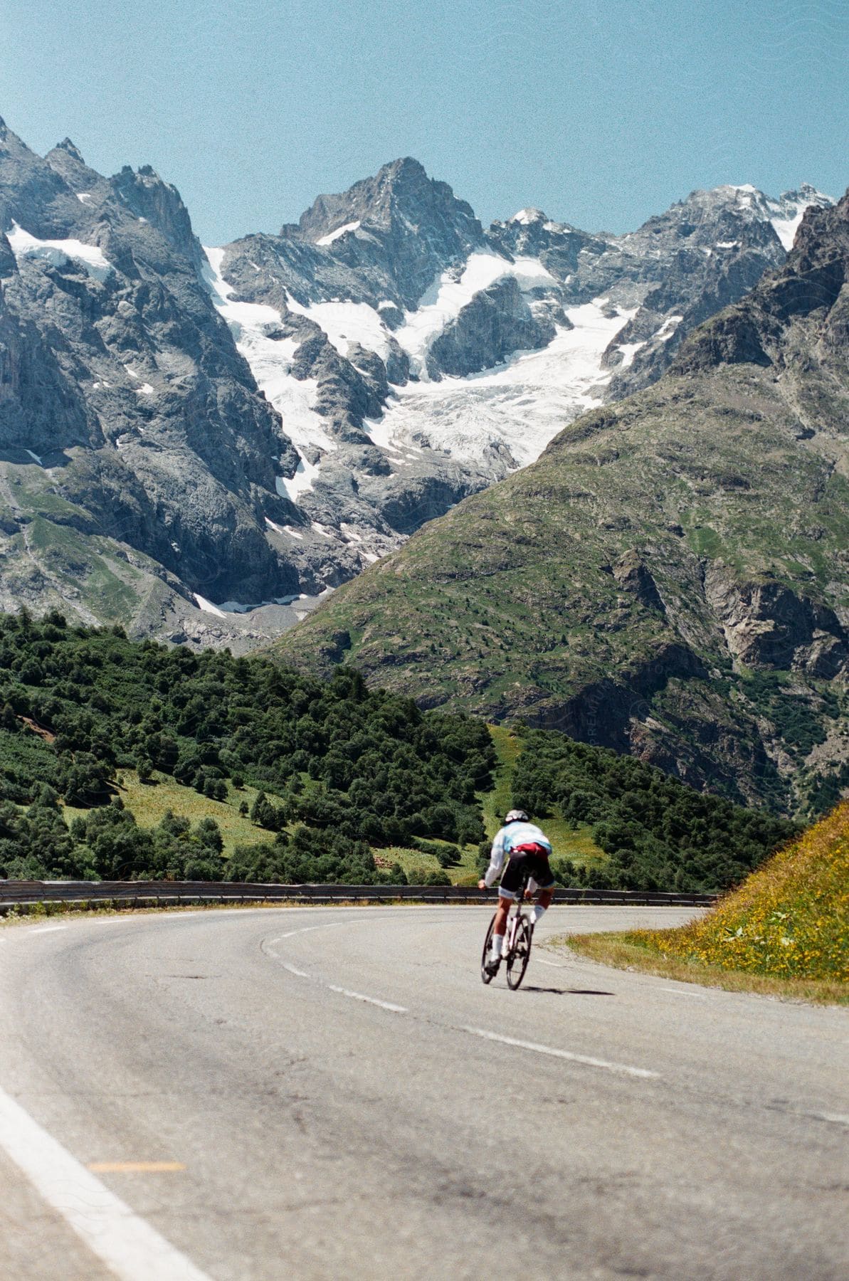 A man riding a bicycle down a road in the mountains