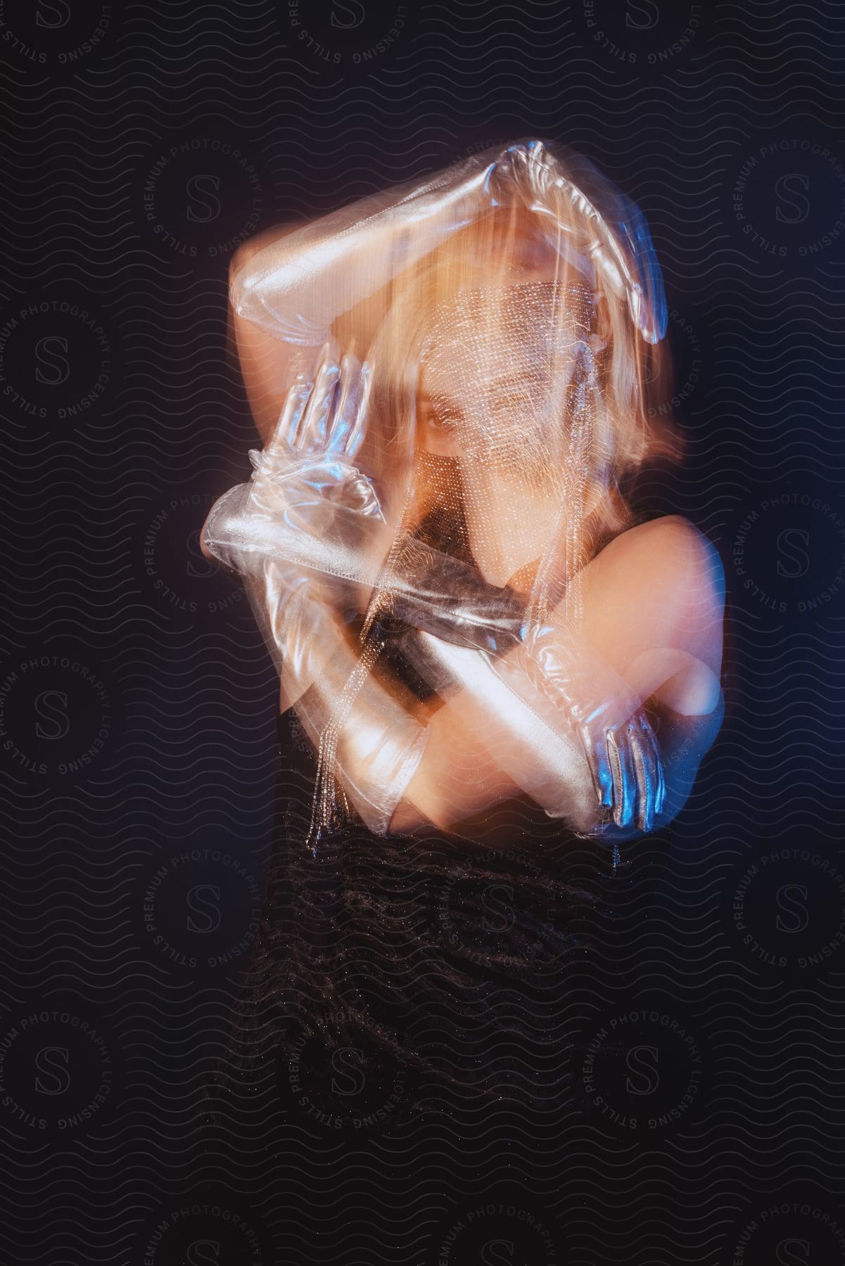 Stock photo of a woman wearing long plastic gloves is dancing with an arm over her head