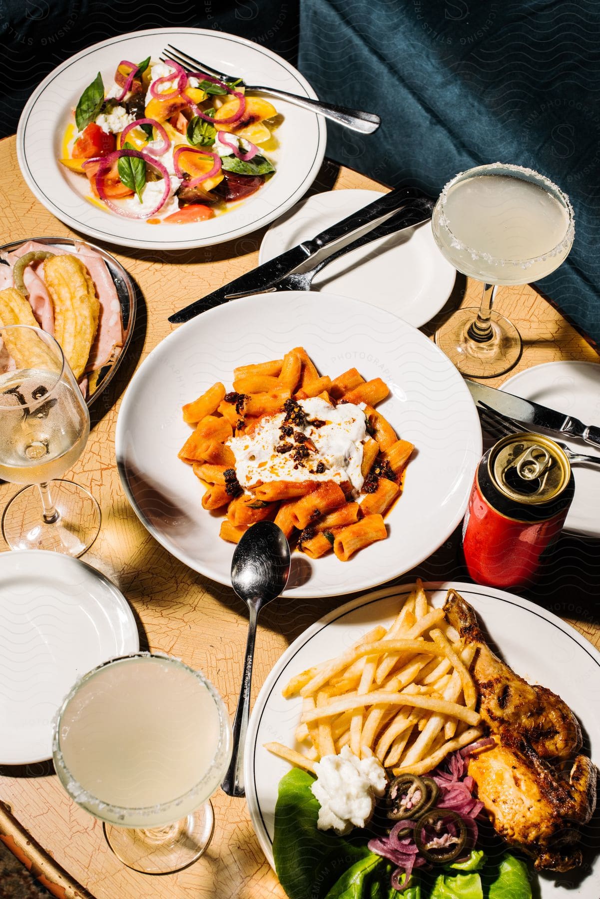 Plates filled with food and cocktails are on the table ready to eat