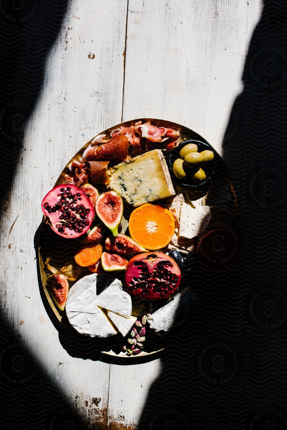 Sunlight shines upon a plate filled with fruits and vegetables