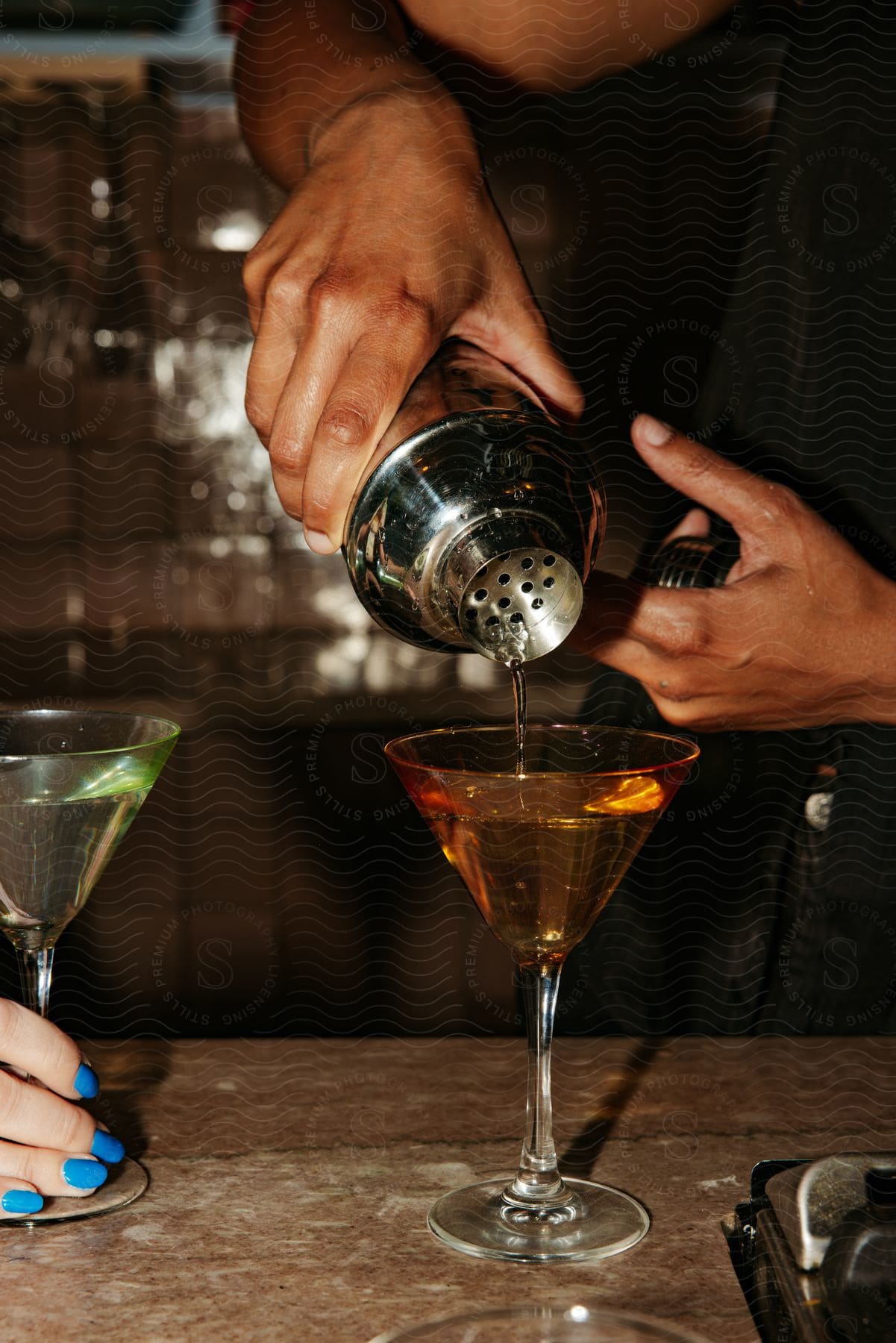 Stock photo of a person preparing a drink in a bar.