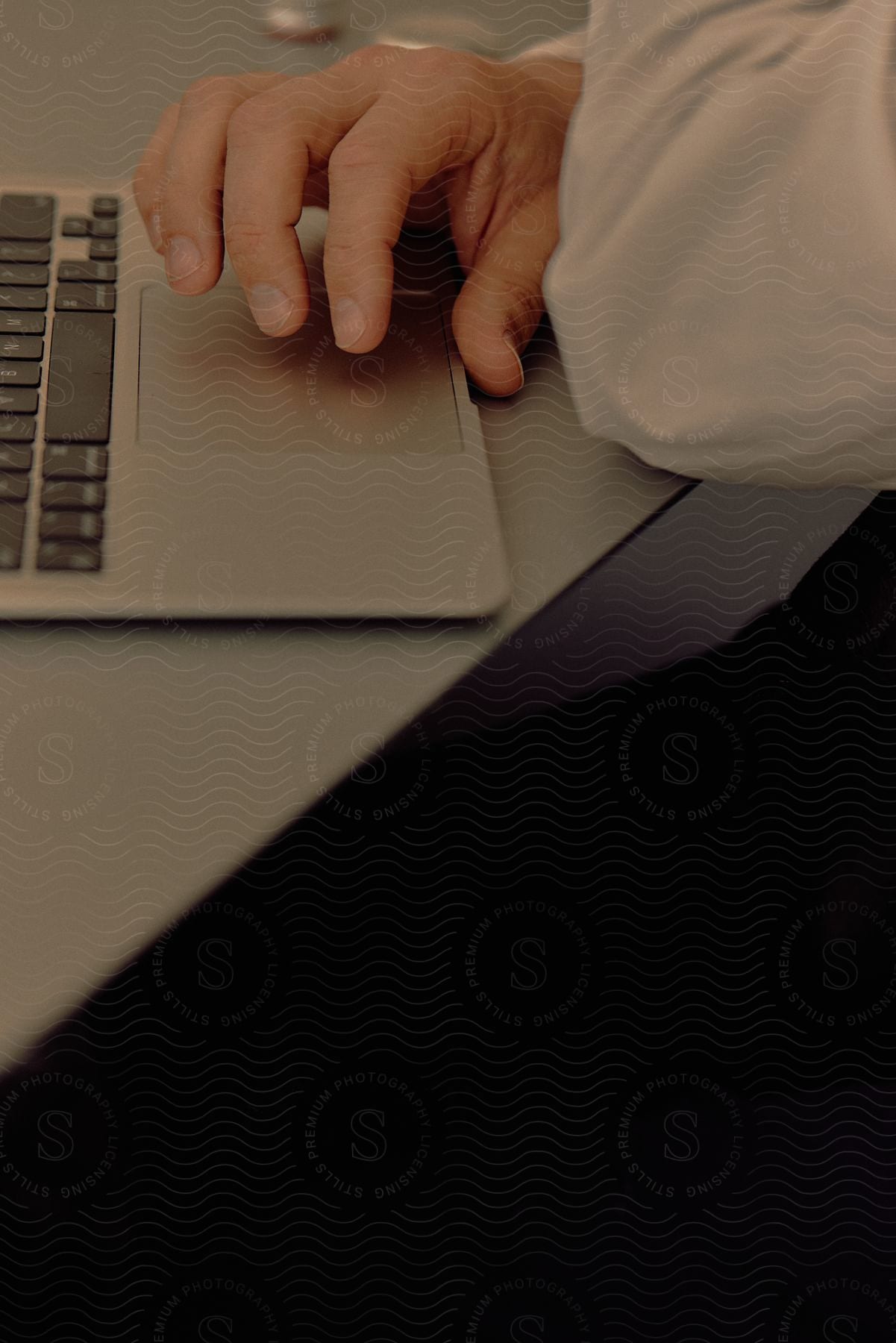 Man wearing a white shirt uses laptop