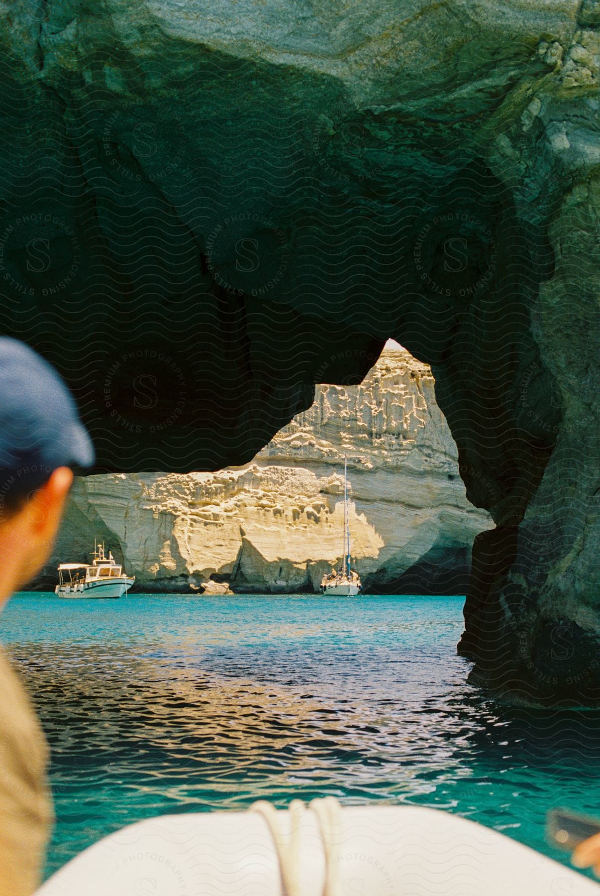 A man observing a space with rocks on top of the water and the water is crystal clear.